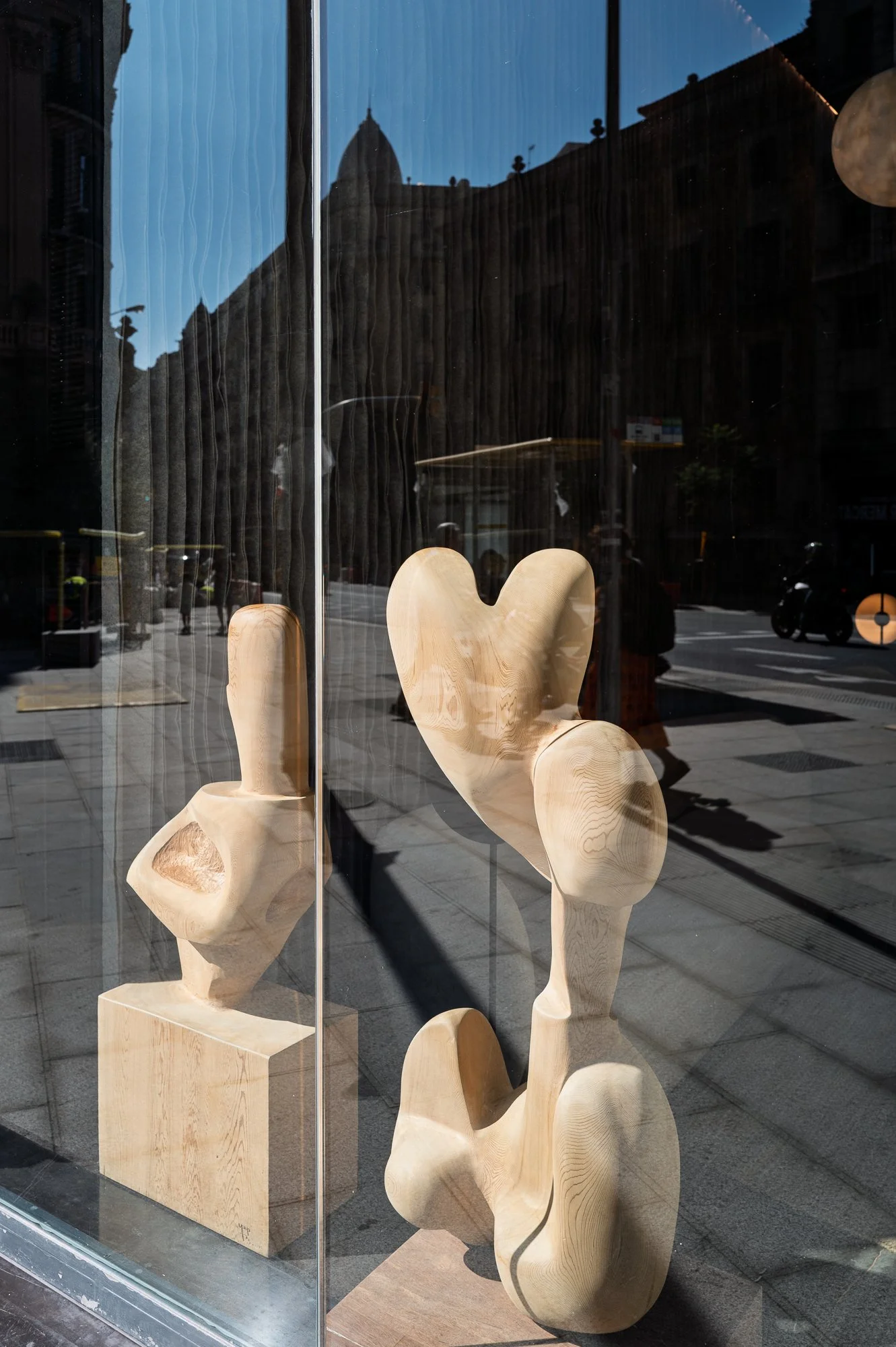 Abstract wood sculptures in a shop window reflecting the street, Barcelona – bCLPhoto