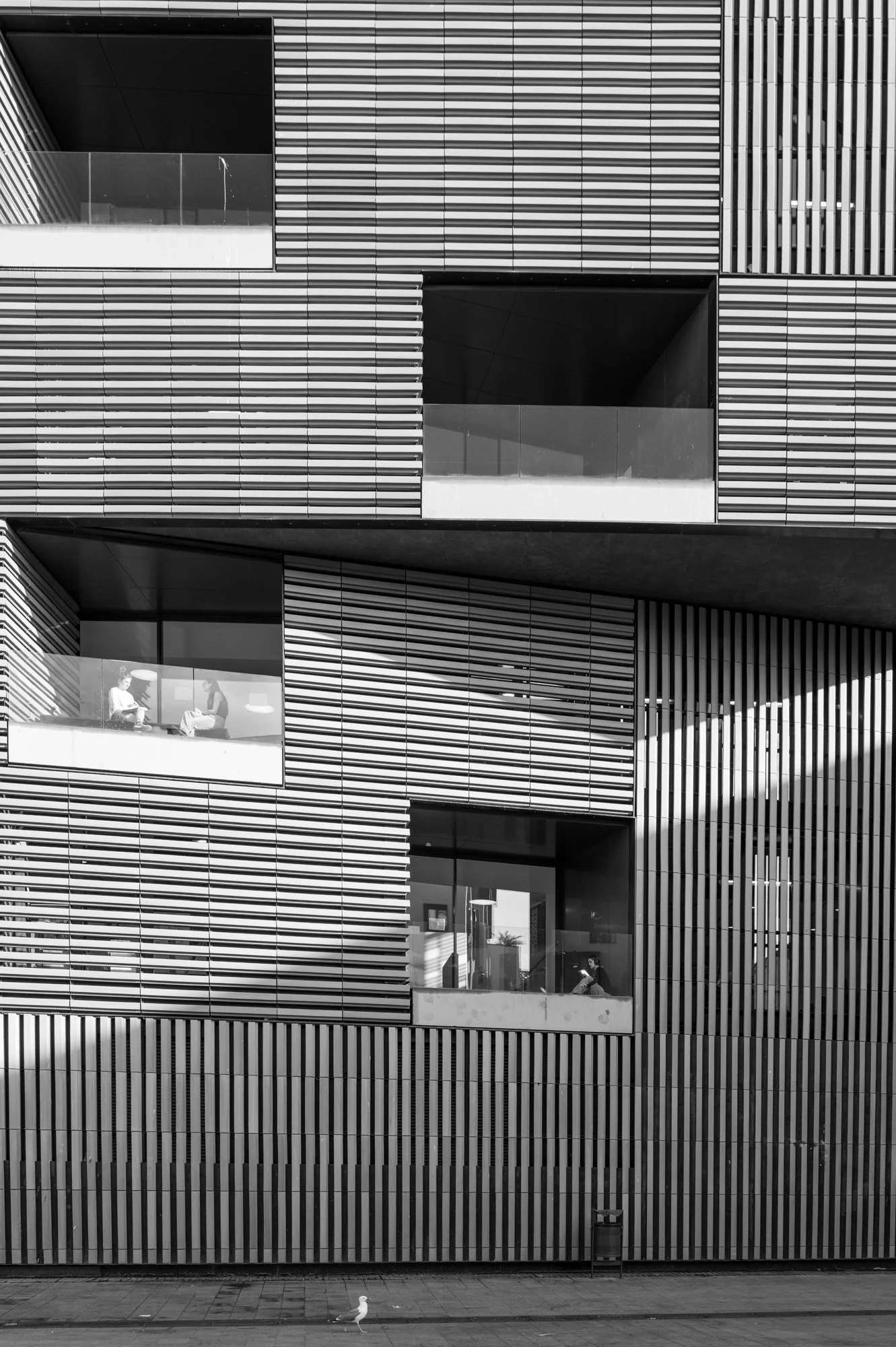 Rhythmic striped facade with figures in windows, Barcelona — Leica Q3