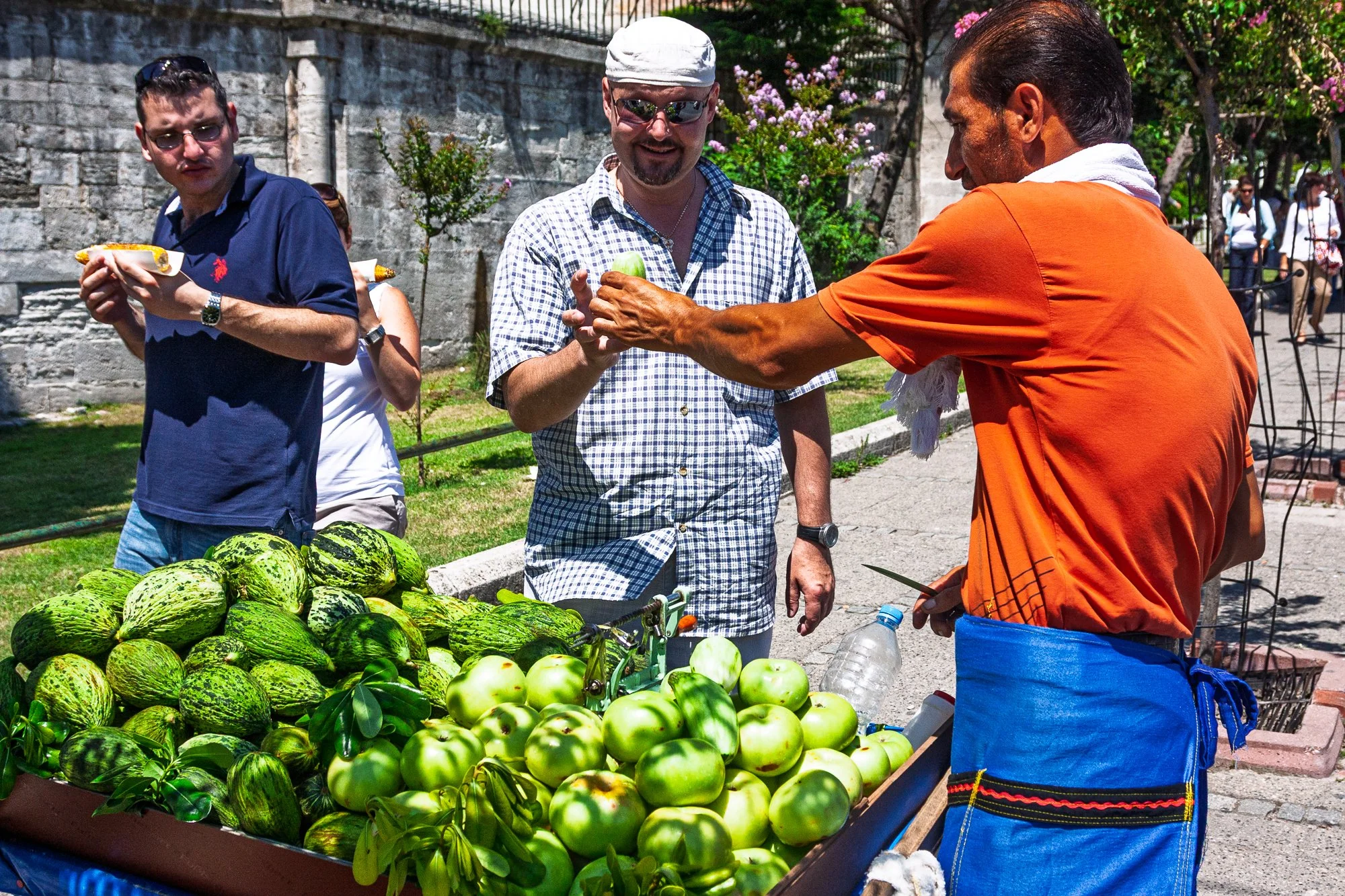 Fruit vendor negotiating a sale with tourists, Istanbul street market — Canon EOS 40D