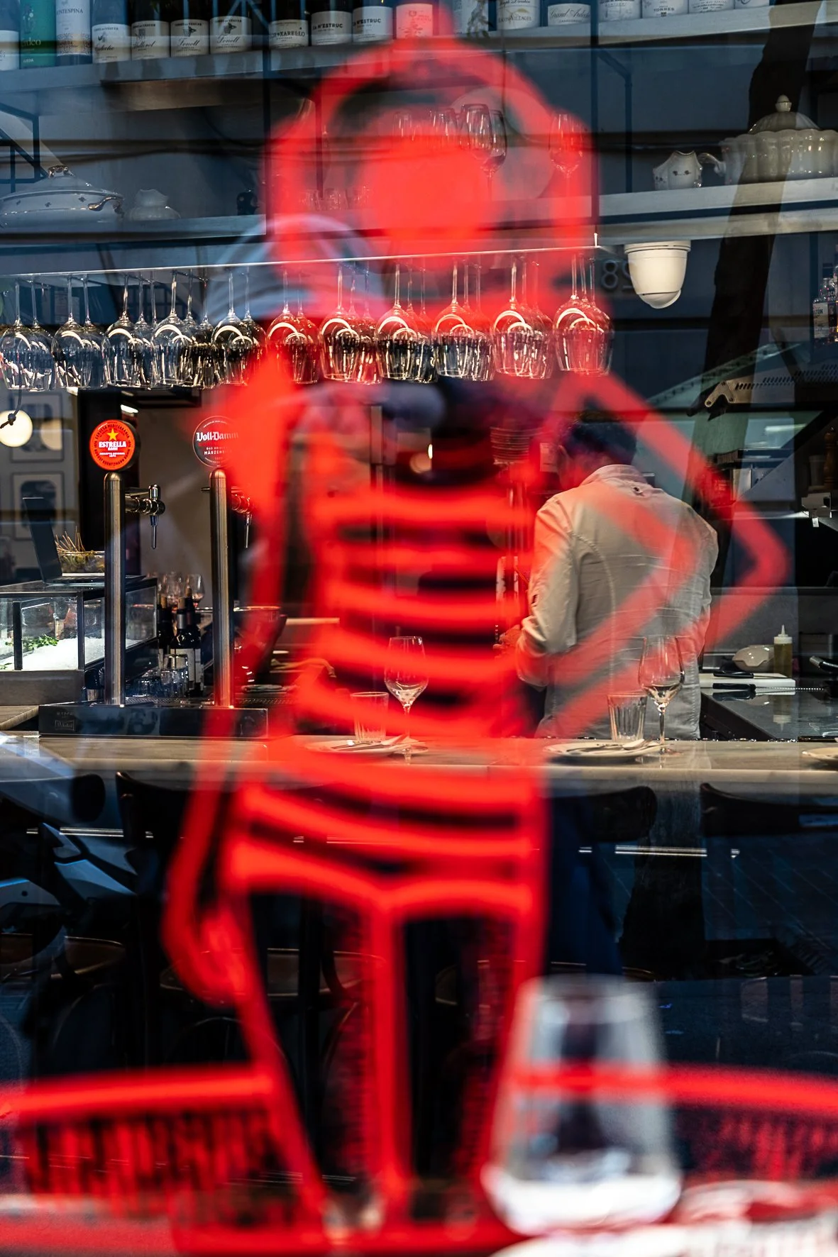 Silhouette of a girl in the glass, the bar with a waiter in the background. Street photography in Barcelona – bCLPhoto