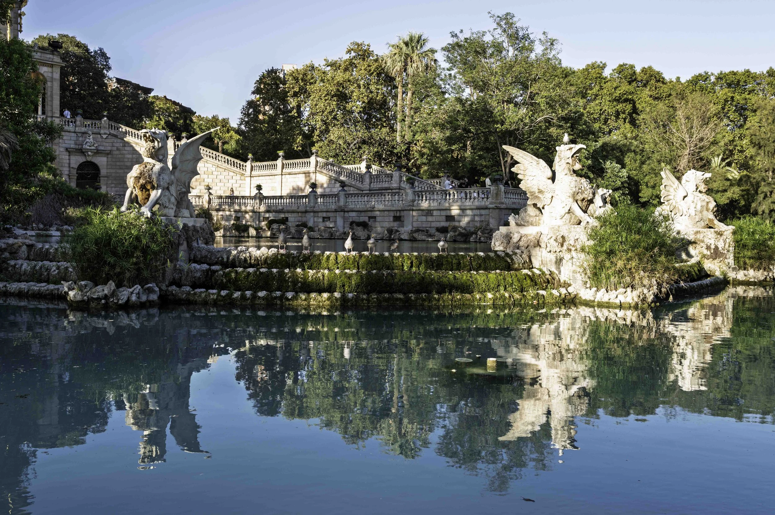 Dragon and griffin sculptures at the Cascada fountain in Parc de la Ciutadella Barcelona reflected in the still water of the pond — Leica Q3