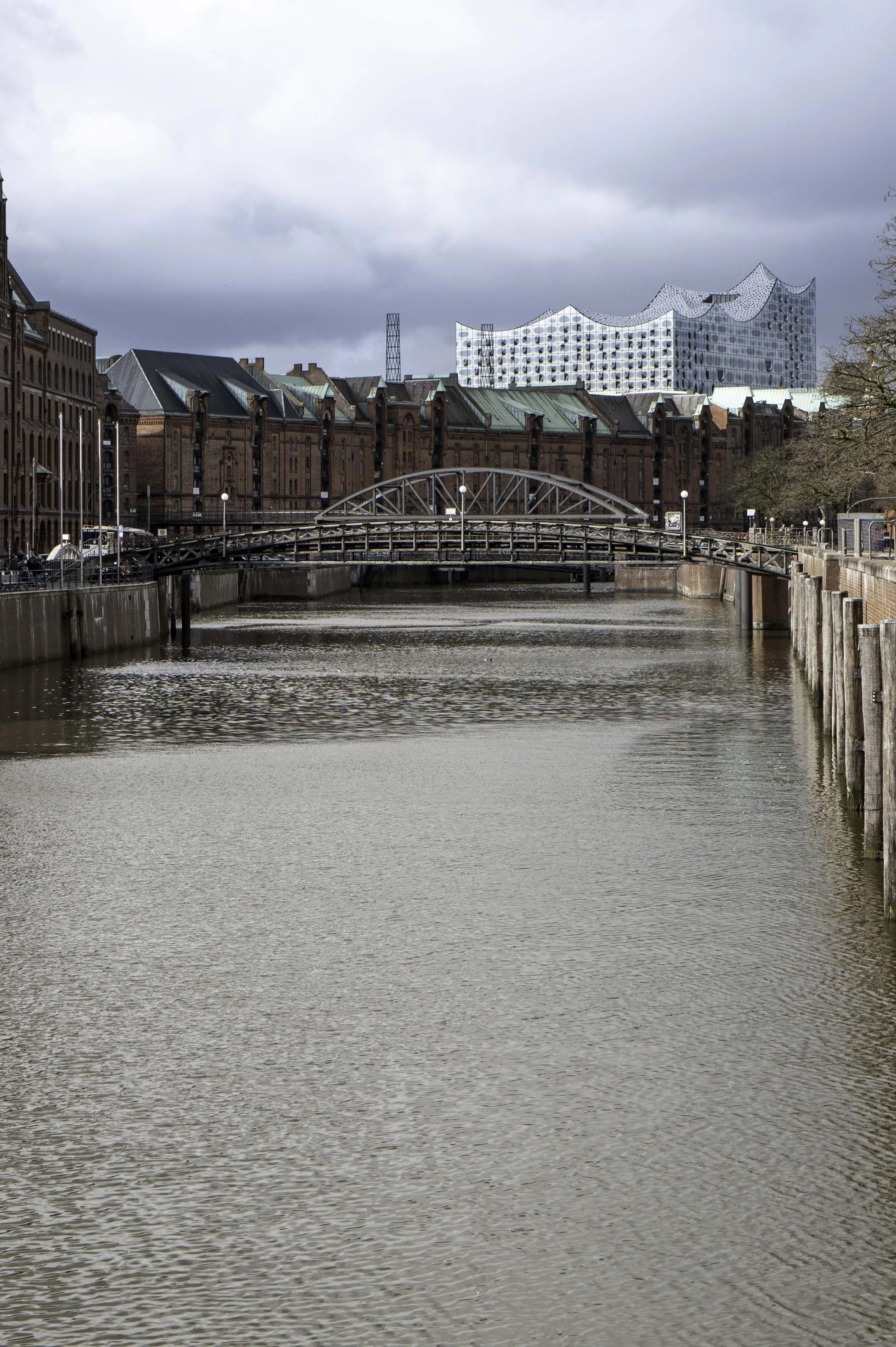 Iron arch bridge over Speicherstadt canal, Elbphilharmonie visible in background, Hamburg — Leica Q3