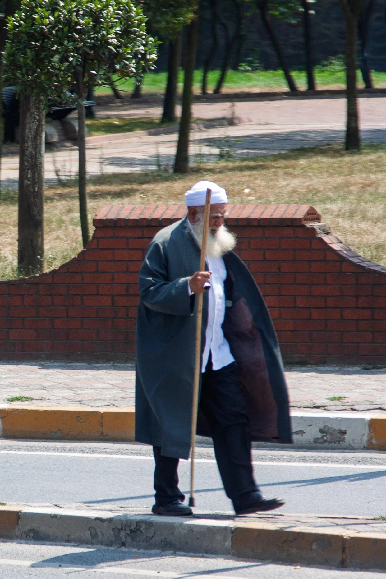 Elderly man with a white beard and cap crossing a street with a wooden cane, Istanbul — Canon EOS 40D