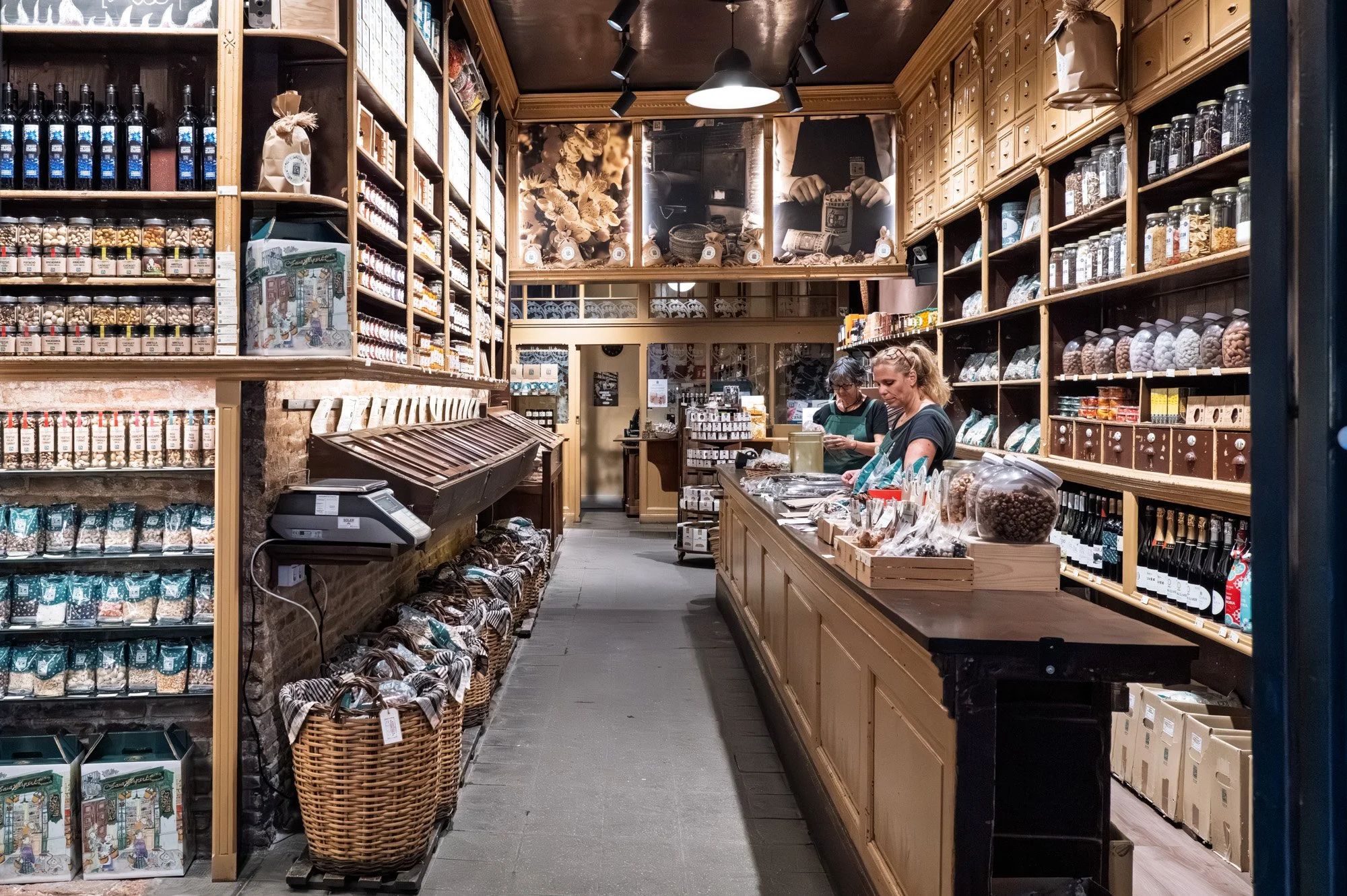 Traditional nuts and wine shop interior in El Born, Barcelona, with wicker baskets and glass jars