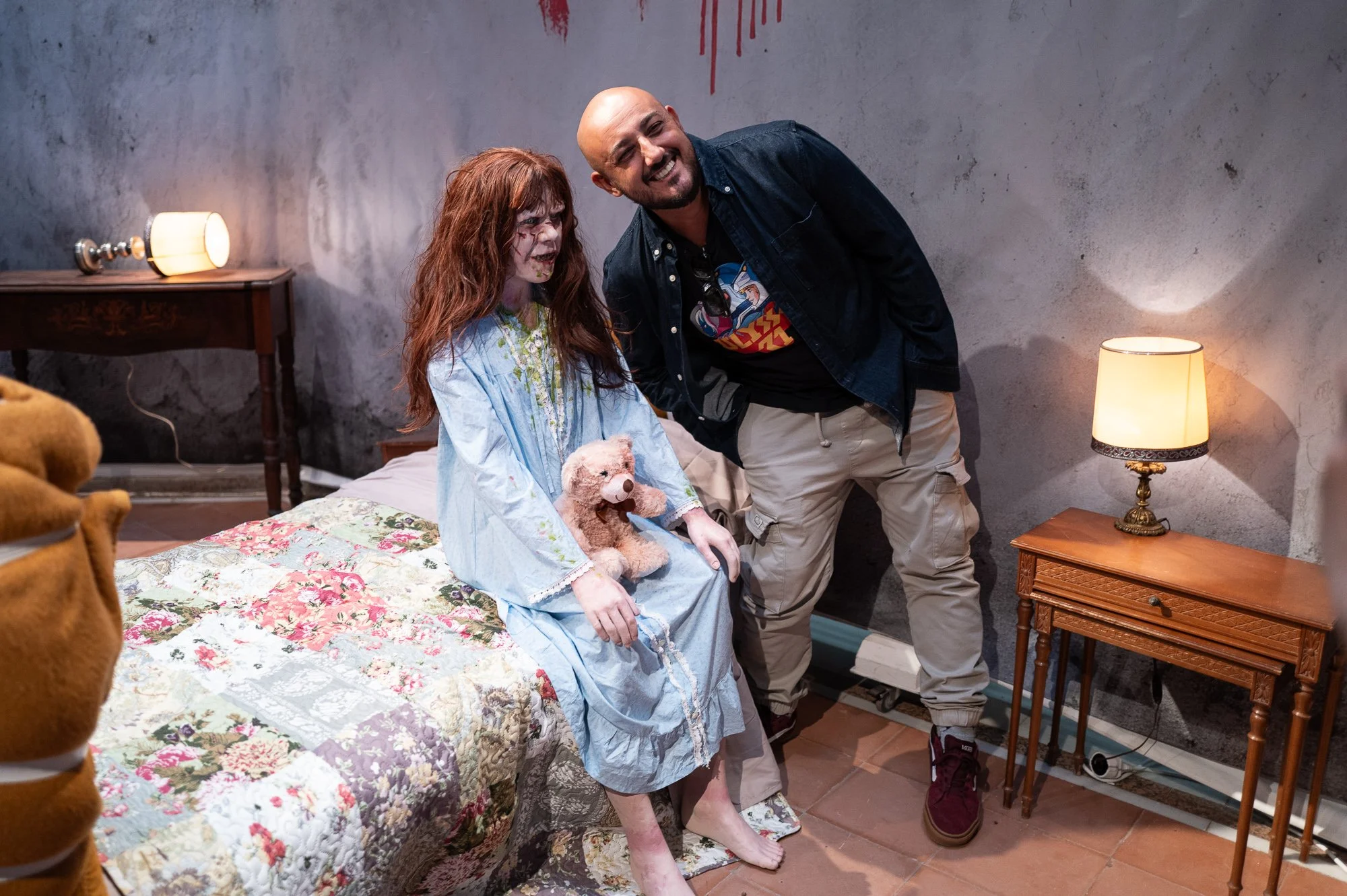 Visitor grinning beside the possessed-girl figure in the recreated Exorcist bedroom, Miramar, Sitges — Leica Q3