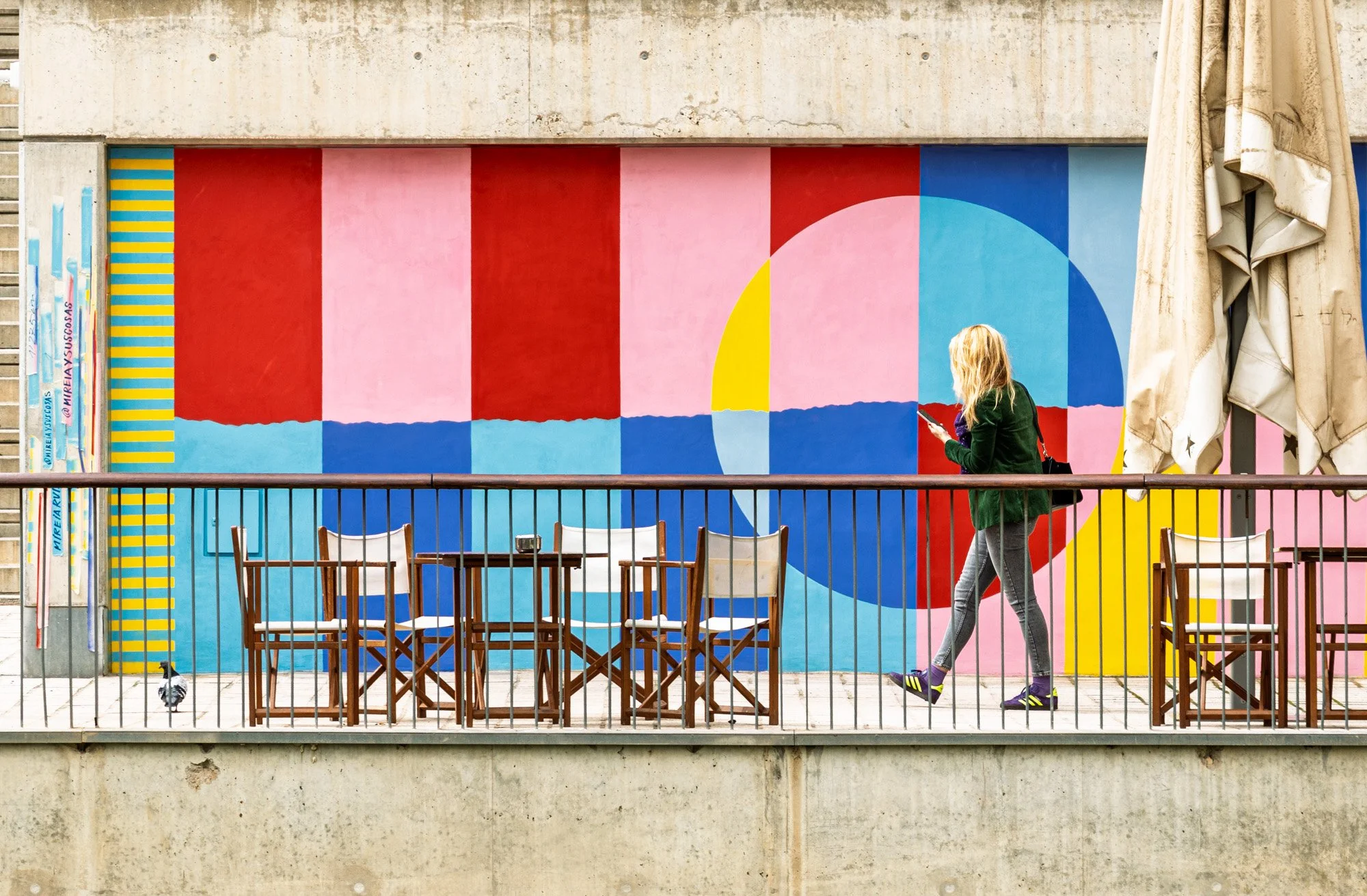 Woman walking past a colourful geometric mural in Barcelona, street art photography — bCLPhoto