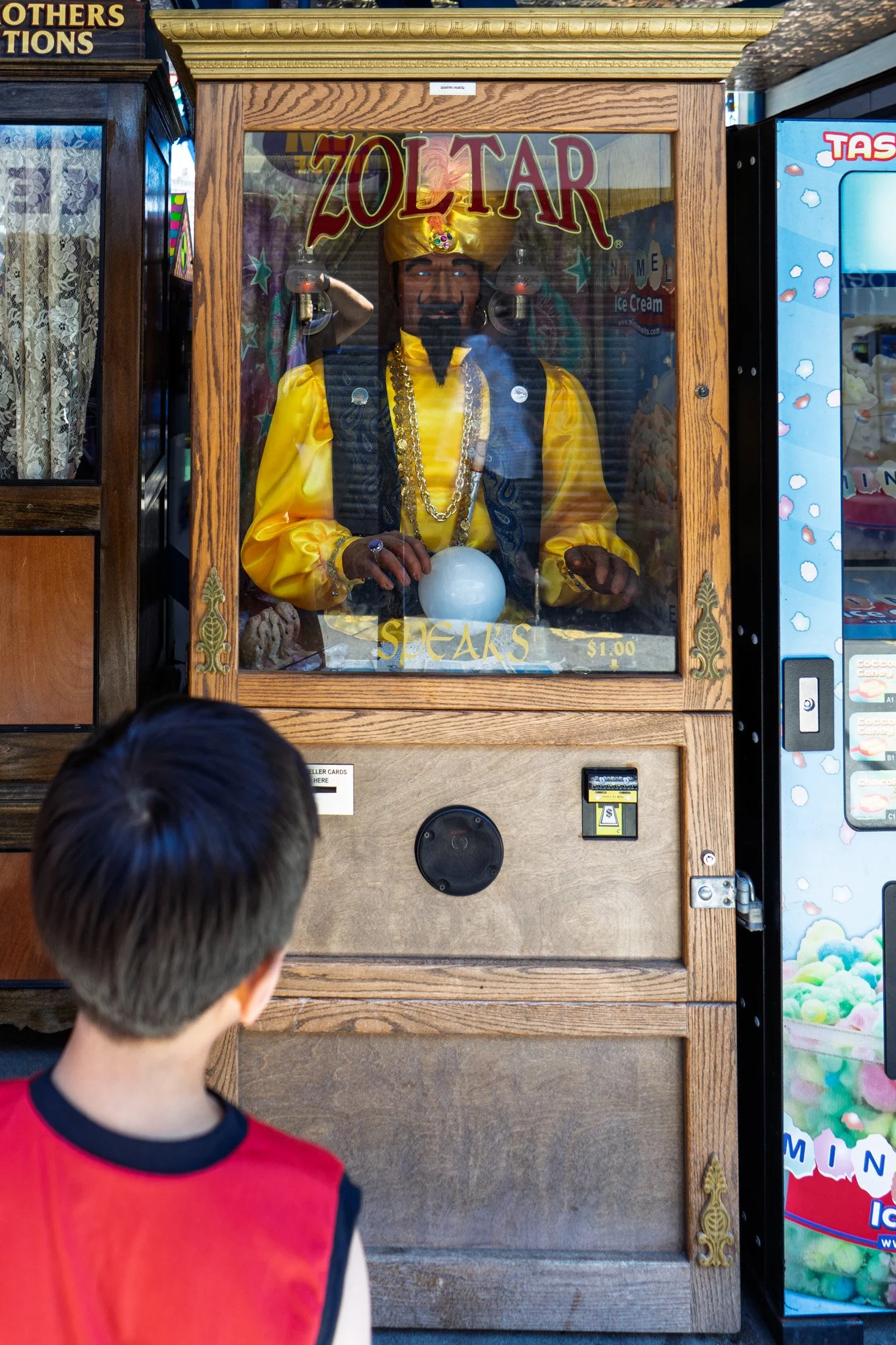 Boy looking at a Zoltar fortune-telling machine – Coney Island street photography – bCLPhoto