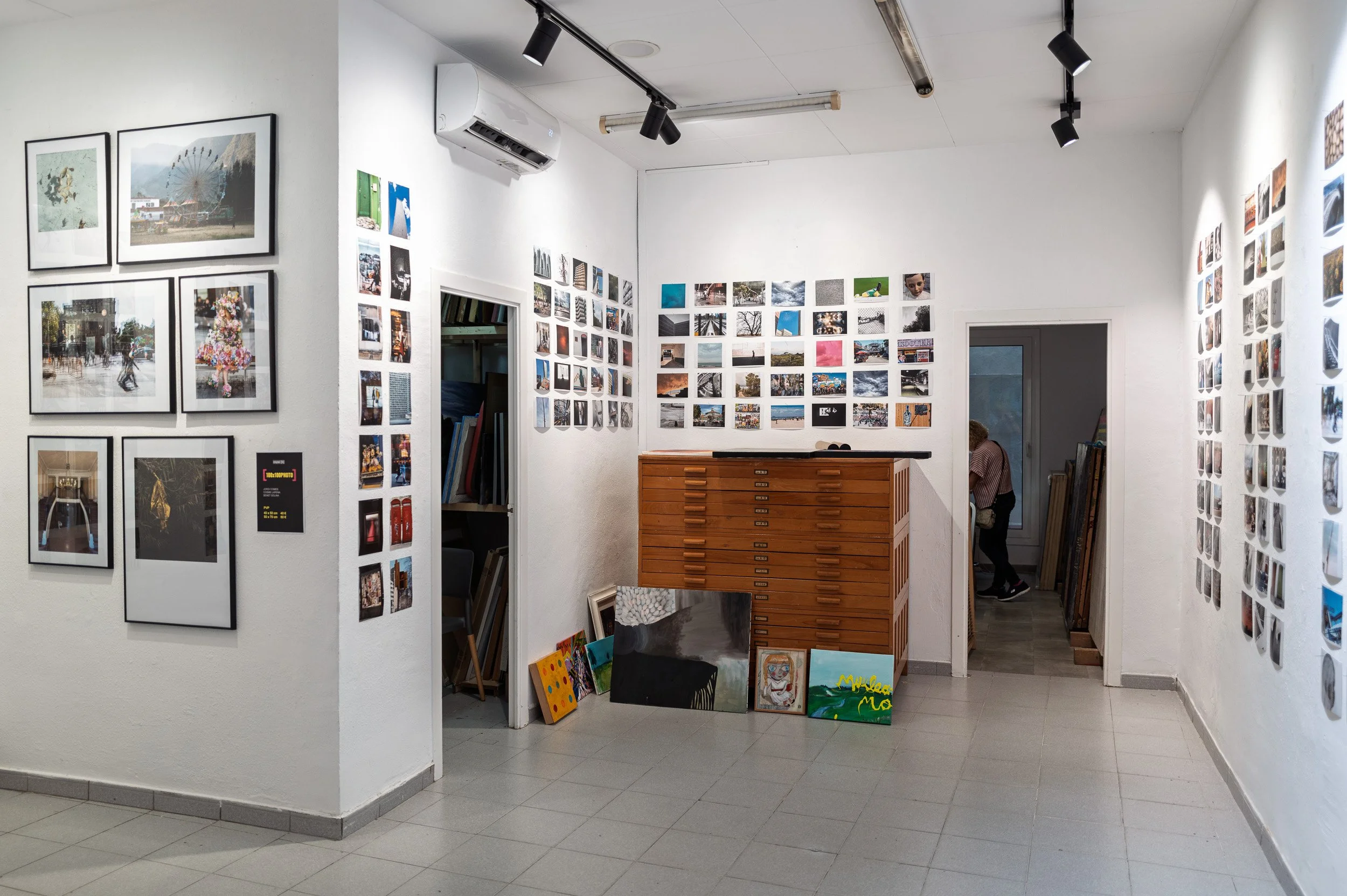 espai[b] gallery interior with framed prints, columns of small photos and a wooden plan chest, Barcelona — Leica Q3