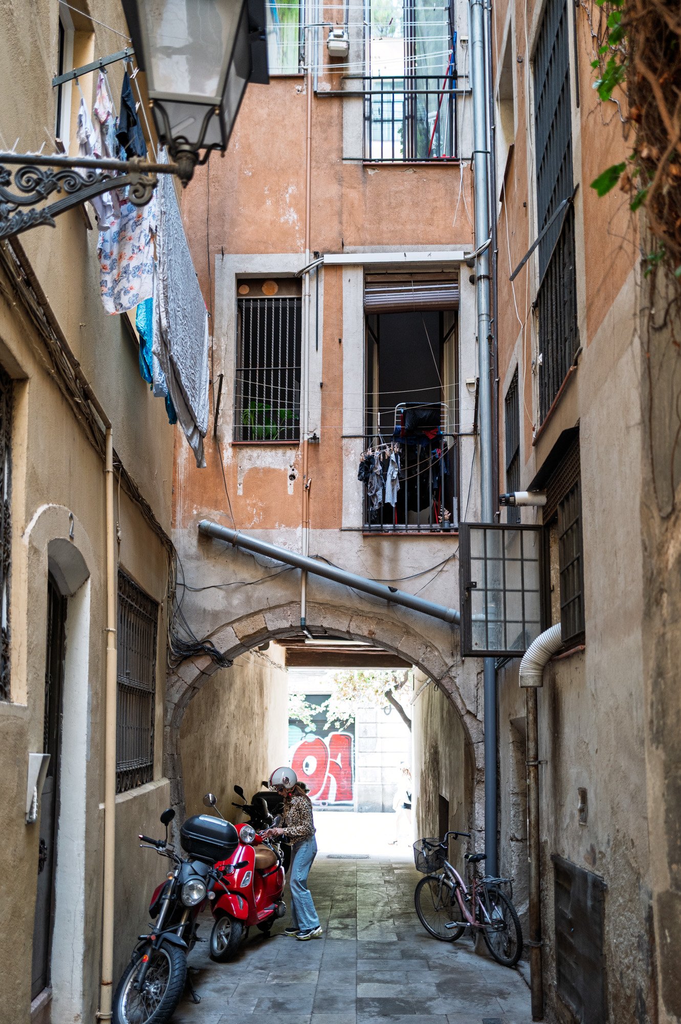Laundry line and graffiti in narrow Barcelona alley — Leica Q3