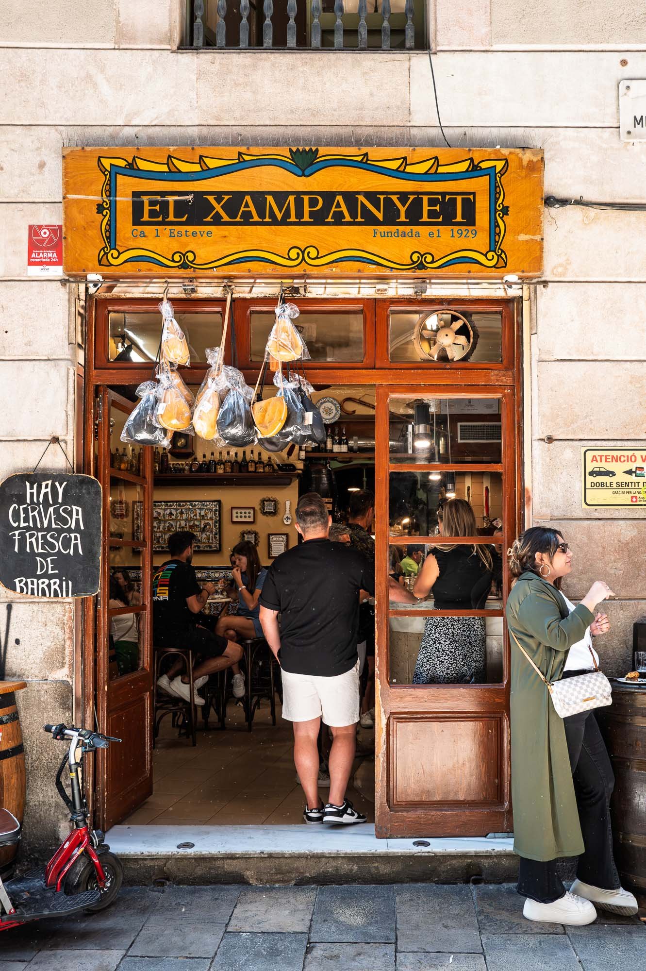 El Xampanyet bar on Carrer de Montcada, El Born, with people at the open door, Barcelona street photography — Leica Q3