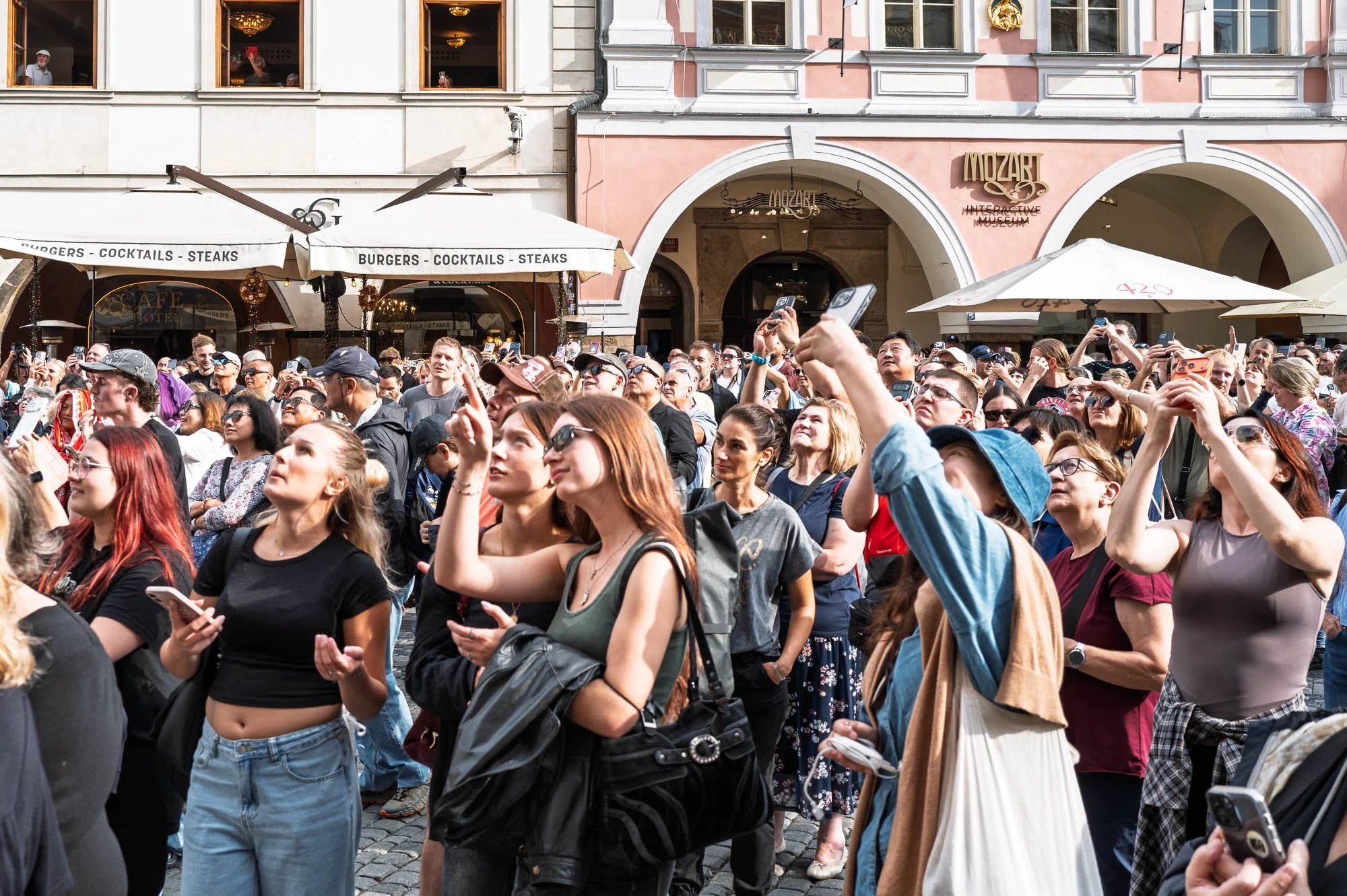 Tourists looking up and filming the Astronomical Clock show, Old Town Square, Prague street photography — Leica Q3