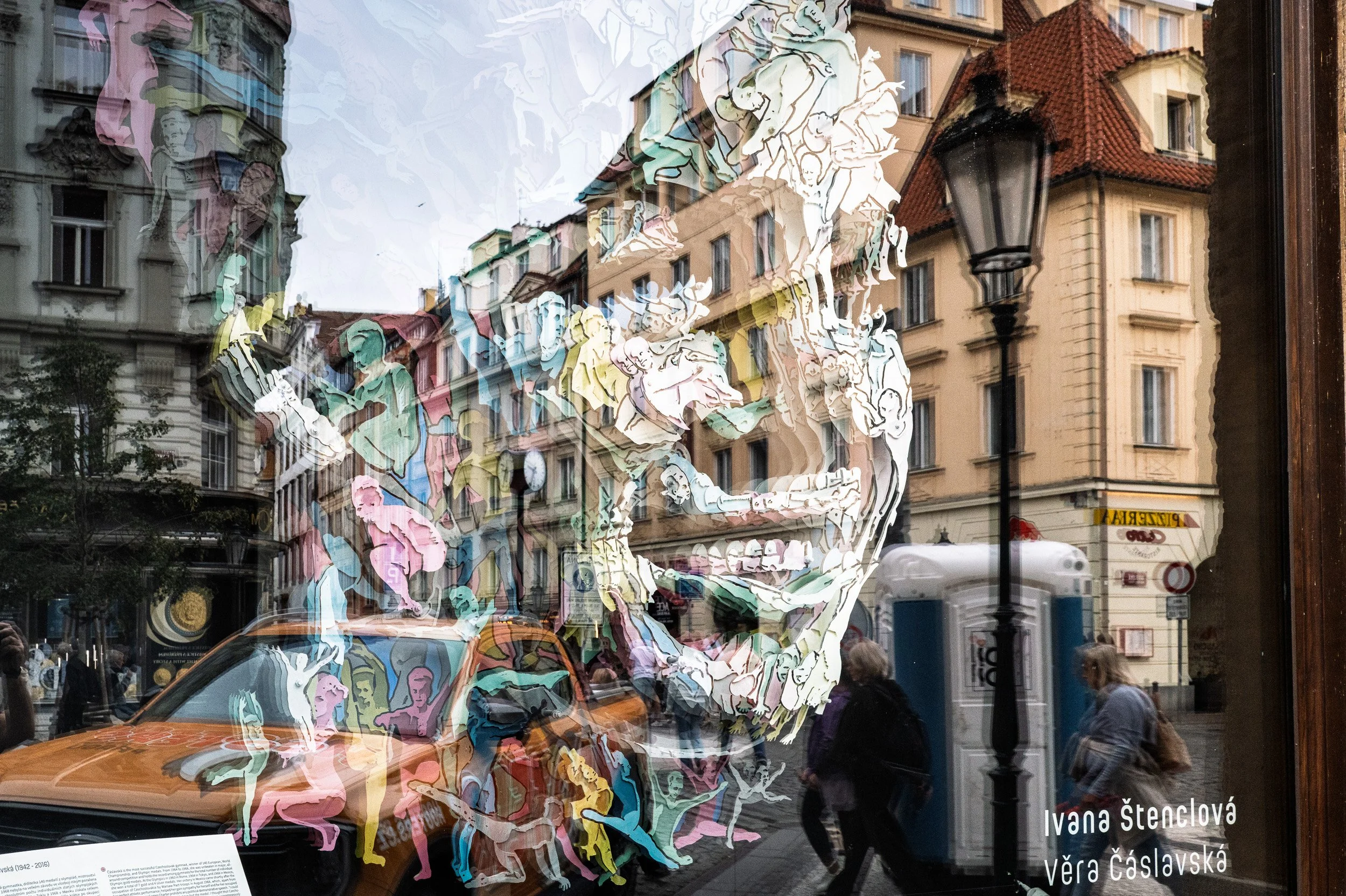 Ivana Štenclová's Věra Čáslavská portrait in a window, street reflected across it, Prague reflections — Leica Q3