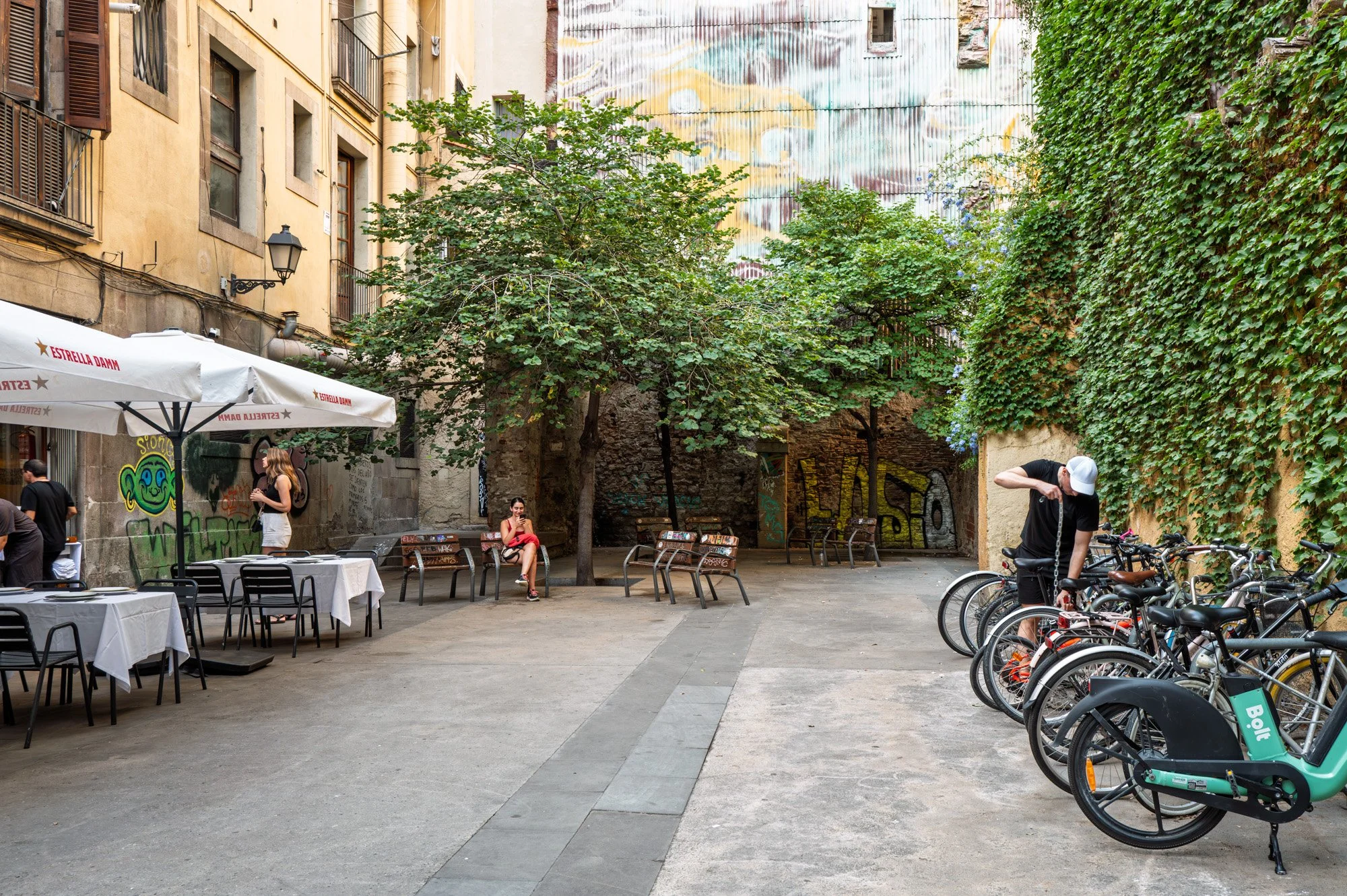 Courtyard with parked bicycles and graffiti wall, El Born — Leica Q3