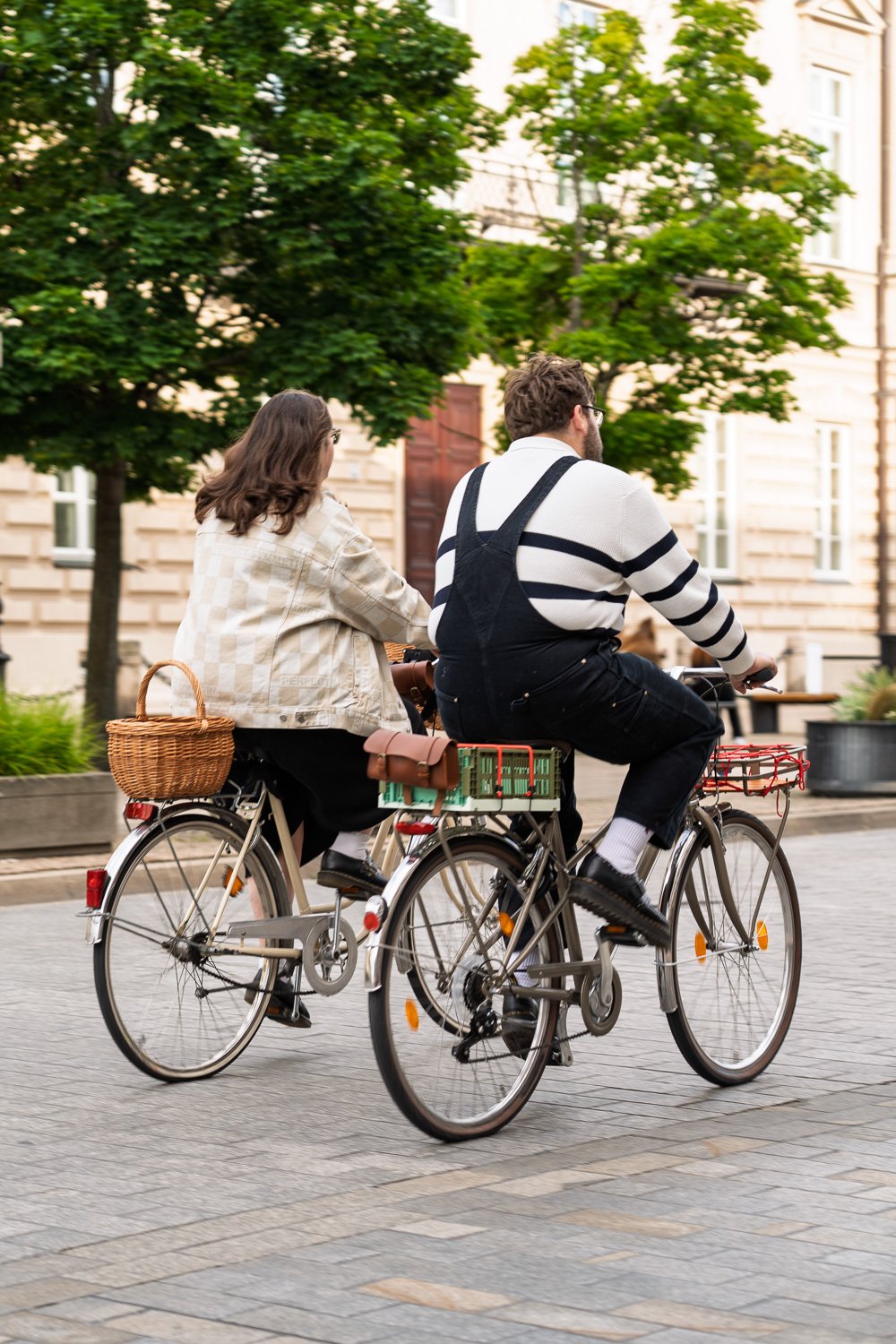 Warsaw Royal Route: a young couple ride vintage bicycles with a wicker basket and crate down a cobbled street — Sony a7R IV