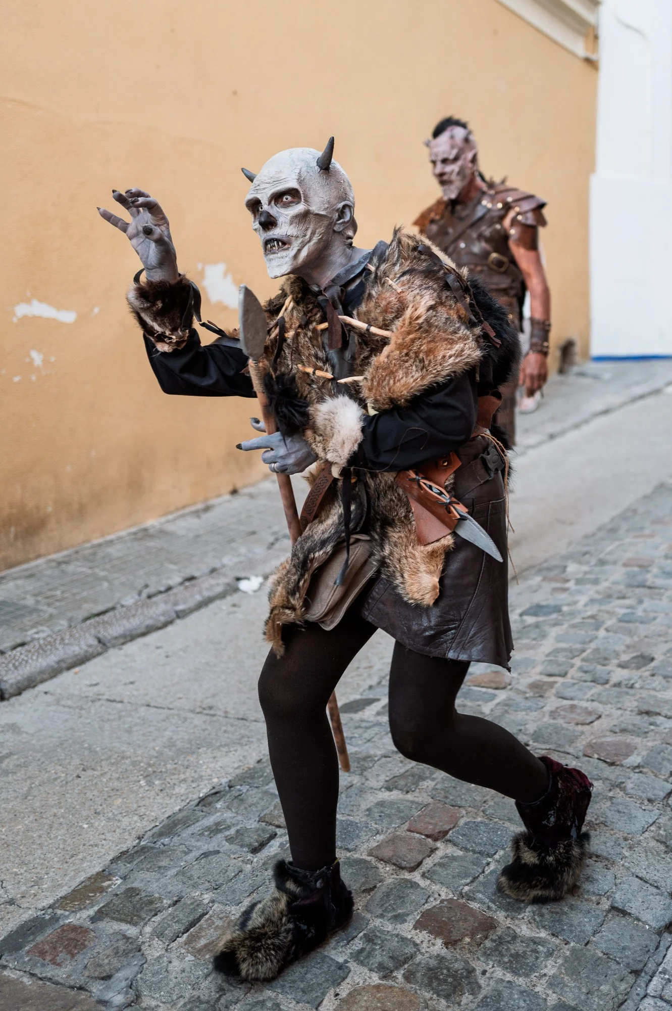 Orc in a horned mask and furs with claws raised on a narrow cobbled street in Sitges — Leica Q3