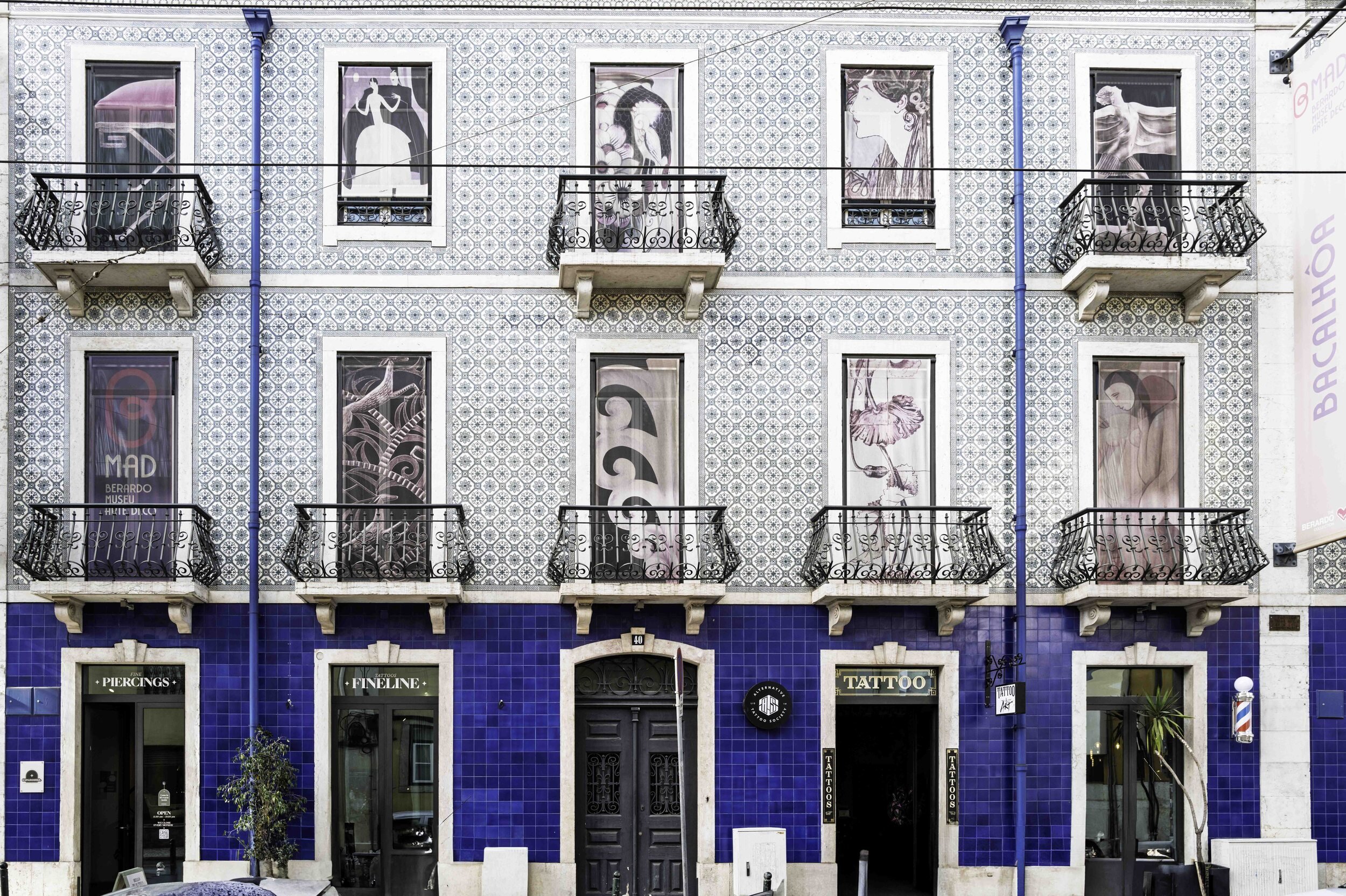 Blue azulejo tiled facade with art gallery posters and tattoo parlour, Lisbon — Leica Q3