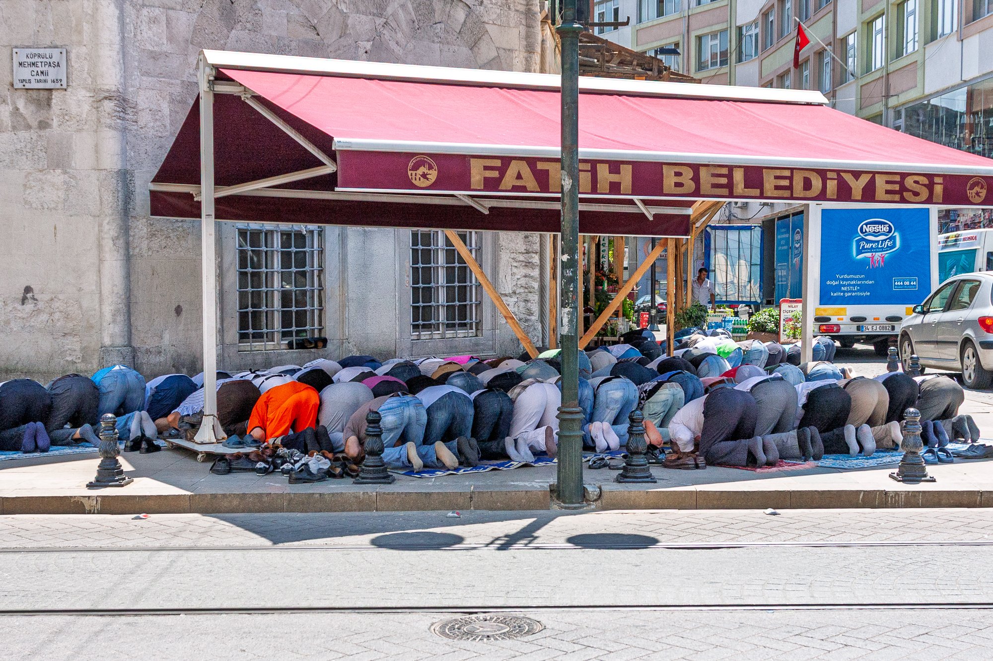 Men praying together under a street awning, Istanbul — Canon EOS 40D