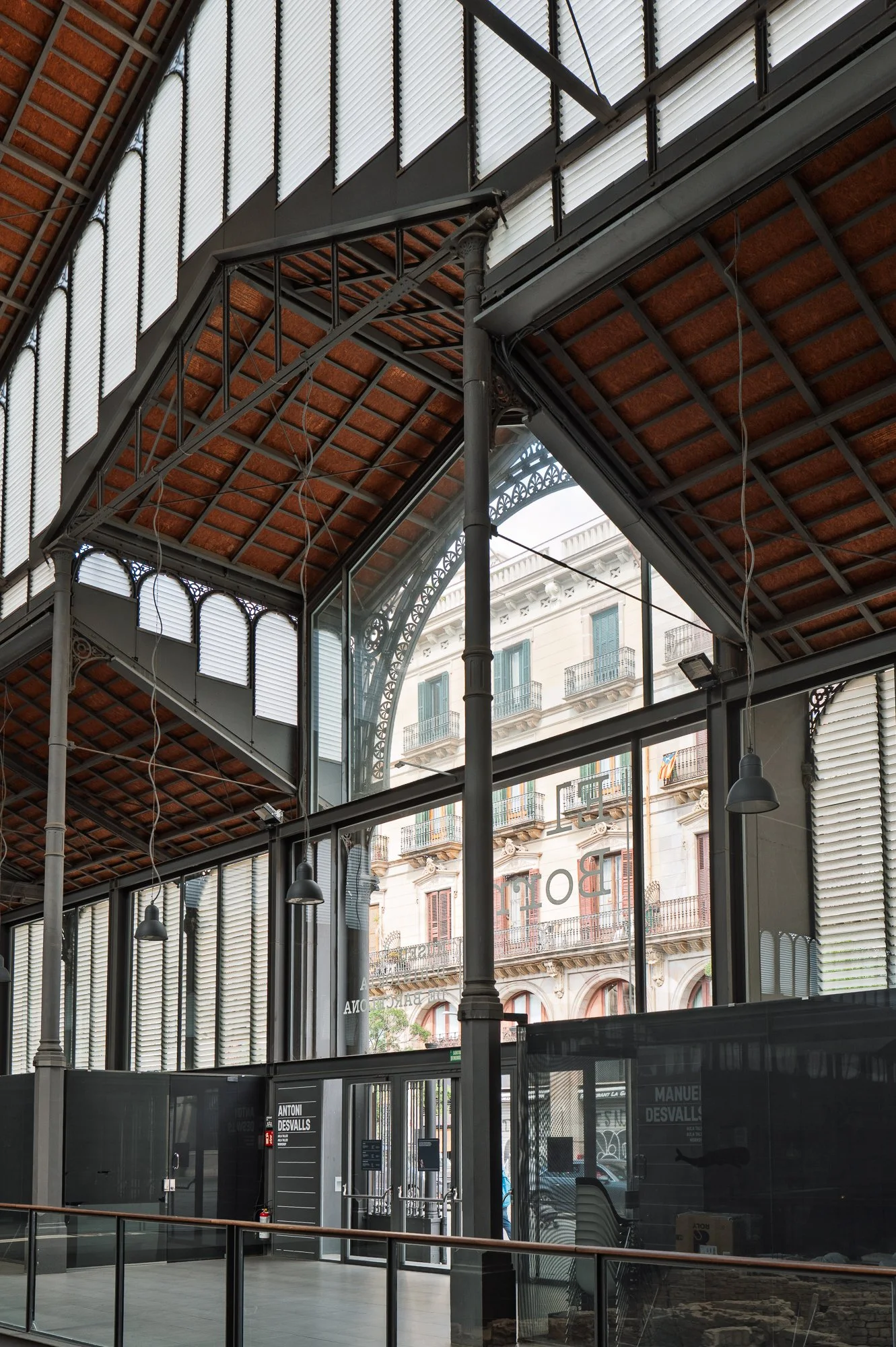 Iron gable and frosted lunettes framing the street outside the Born market — Leica Q3