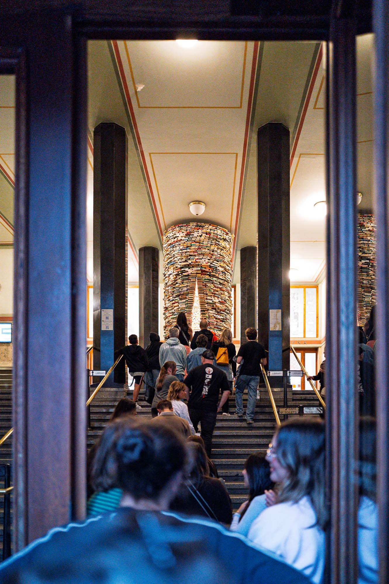 Visitors climbing the stairs towards the Idiom book tower, Municipal Library, Prague — Leica Q3