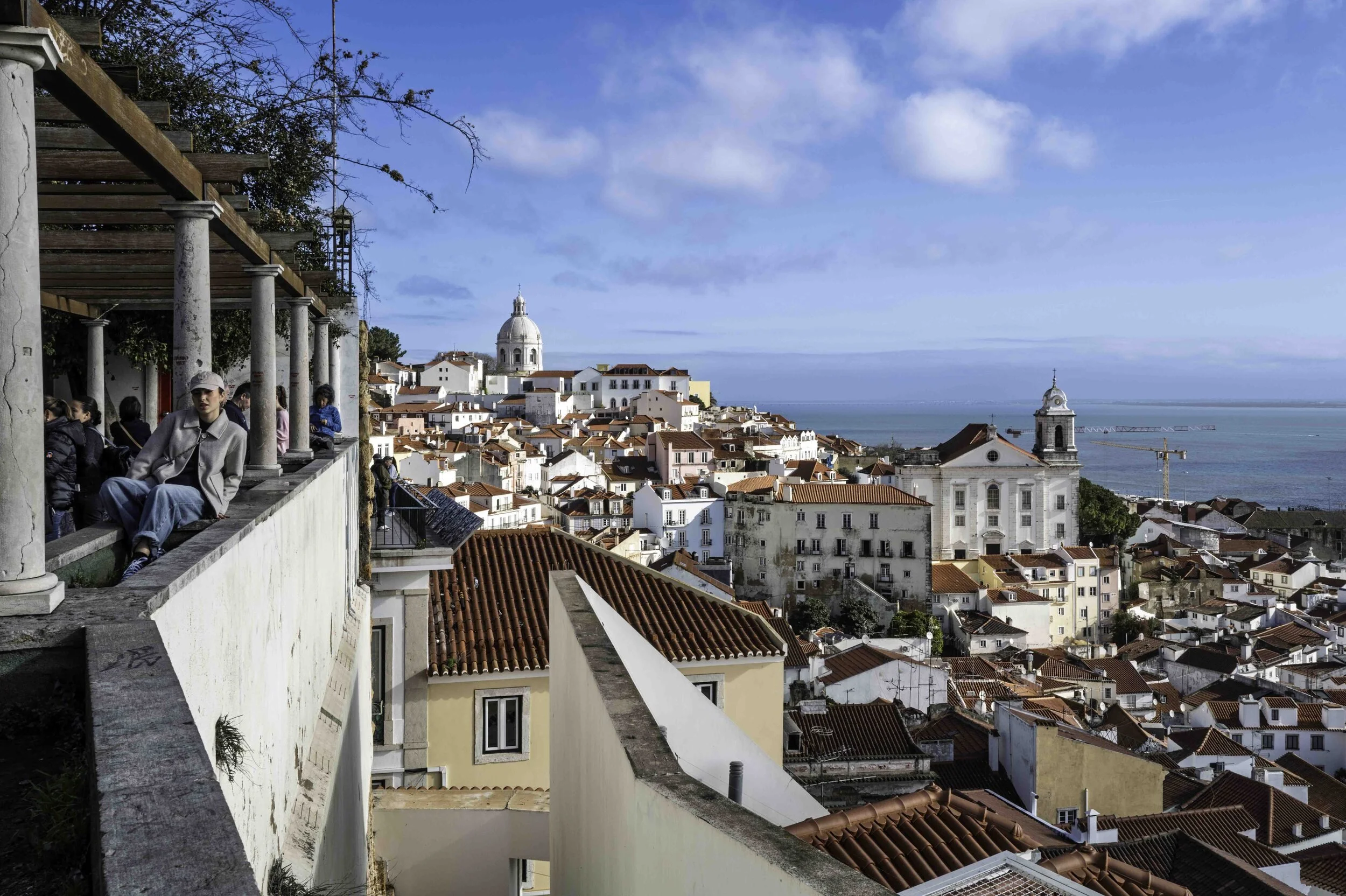 Alfama rooftops and Tagus estuary from Miradouro das Portas do Sol, Lisbon street photography — Leica Q3