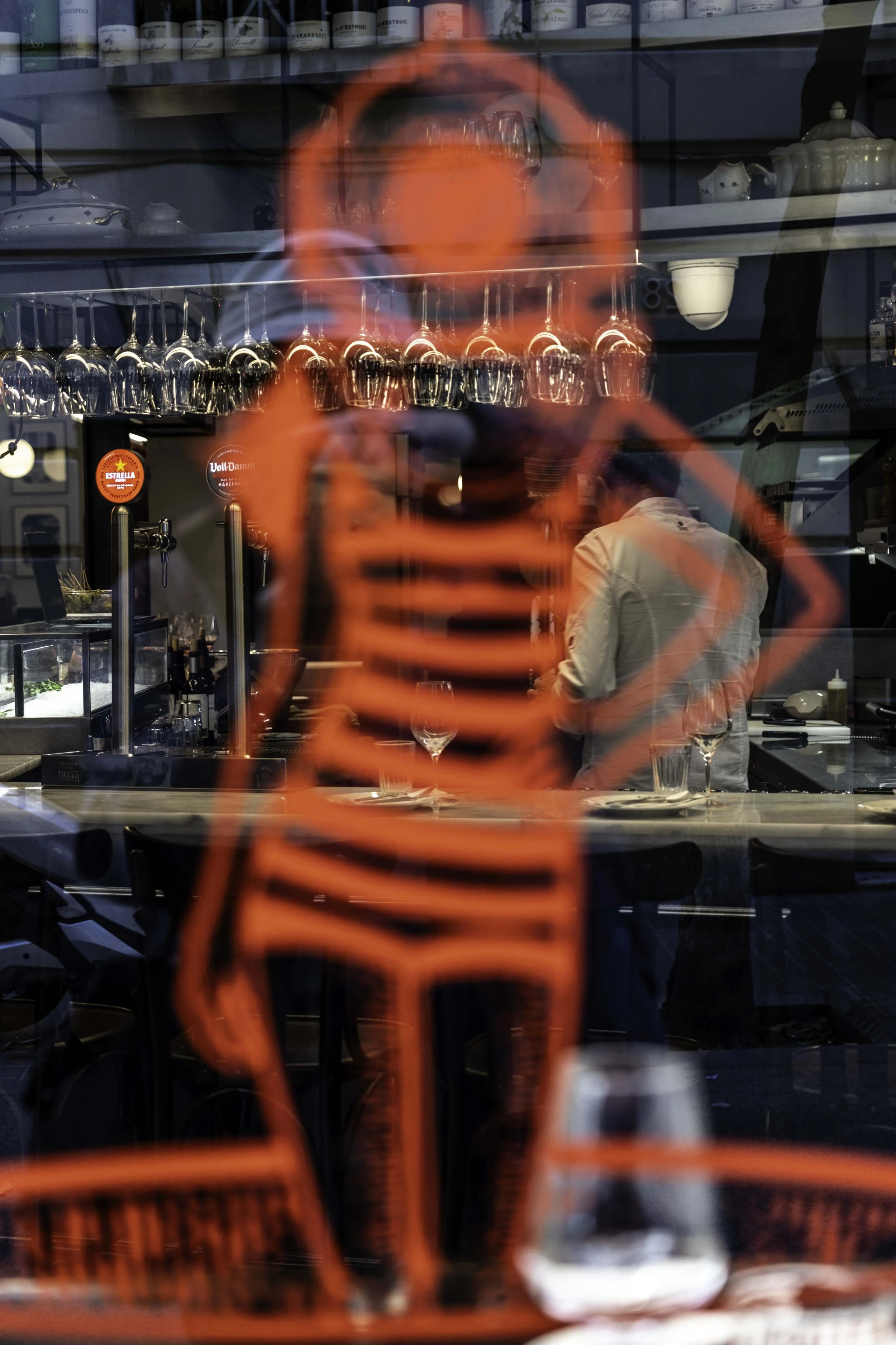 Silhouette of a girl in the glass, the bar with a waiter in the background. Street photography in Barcelona – bCLPhoto