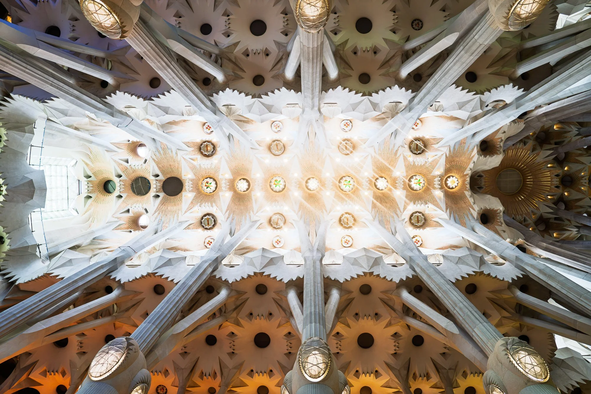 Symmetrical Sagrada Família vault ceiling with light rays and stained circles  — bCLPhoto