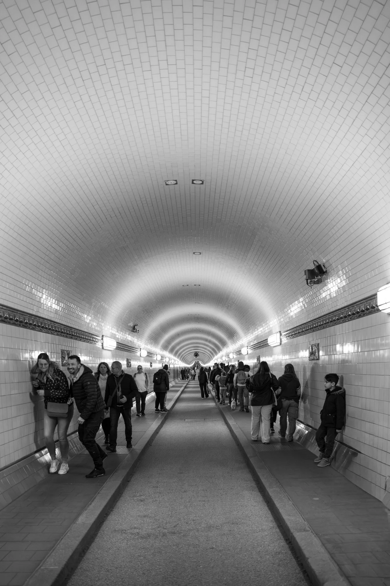 Inside the historic St. Pauli Elbe Tunnel with crowds walking through the arched white-tiled corridor, Hamburg — bCLPhoto