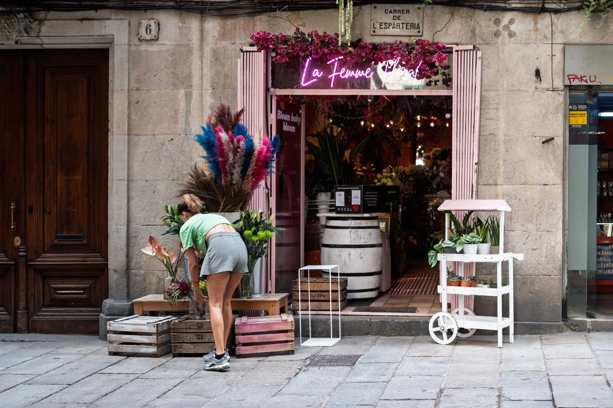 Florist arranging flowers outside La Femme Floral on Carrer de l'Esparteria in El Born, Barcelona