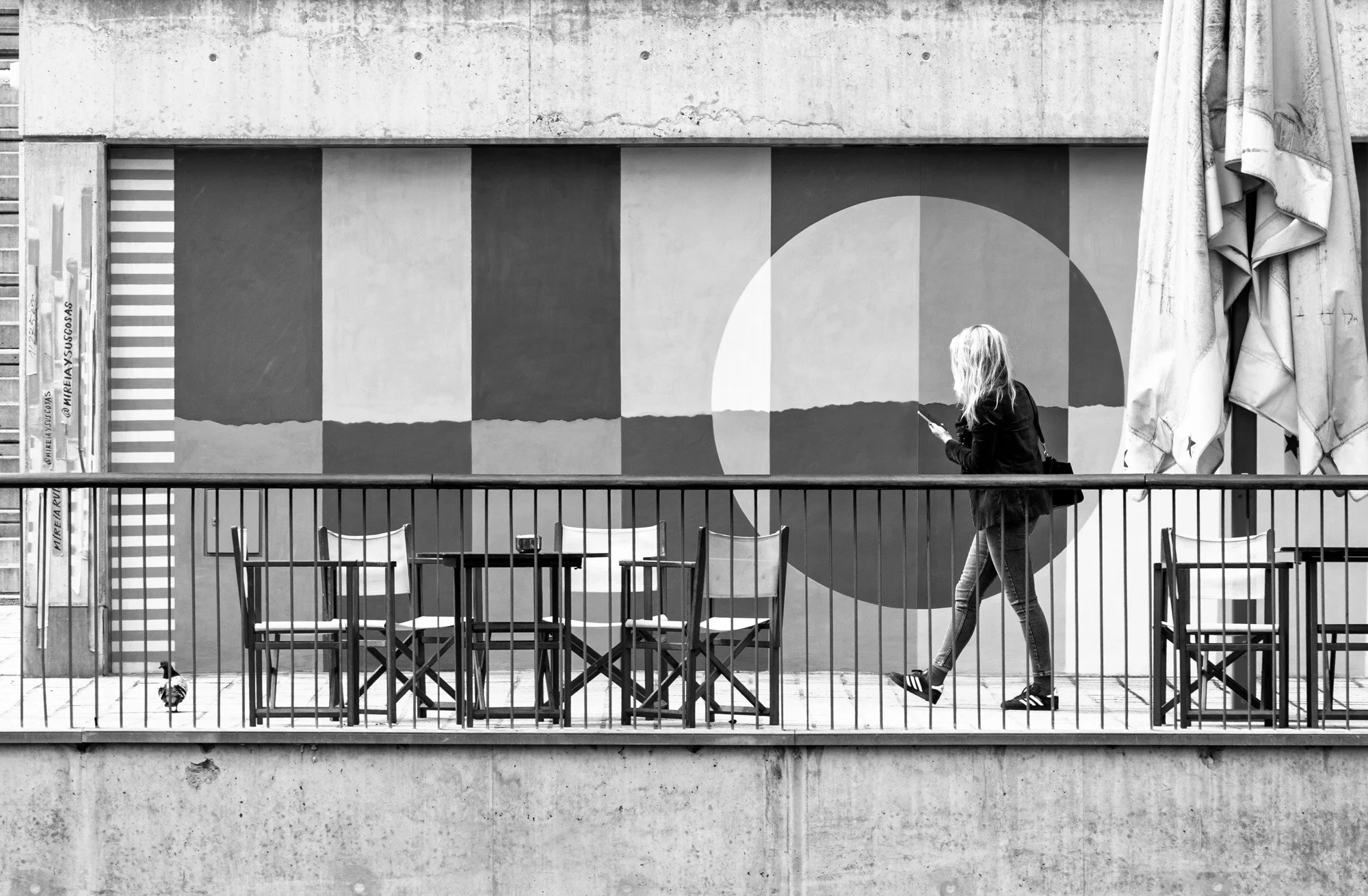 Woman on phone against geometric mural terrace, Barcelona — Sony A7R IV