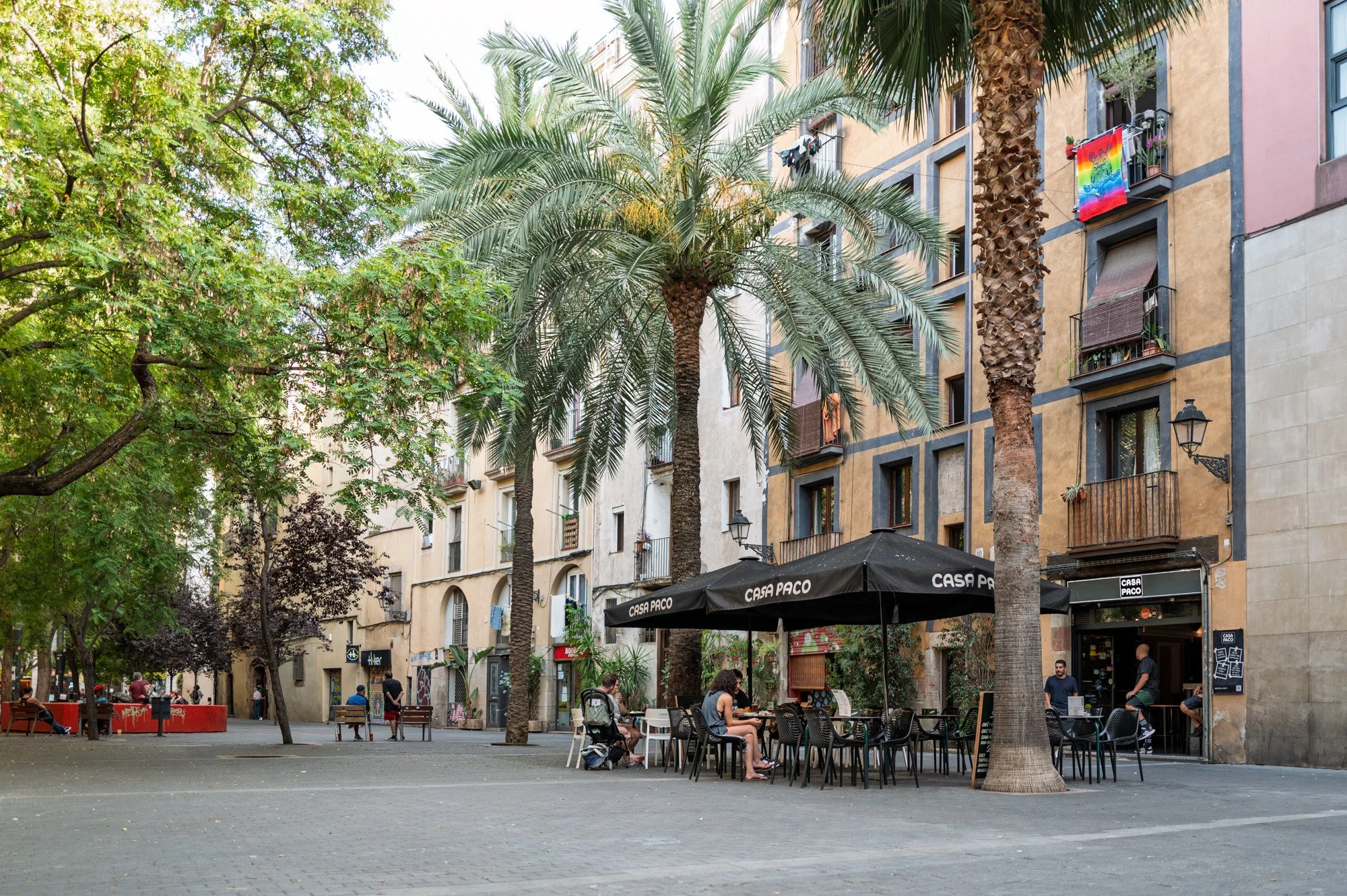 Palm-lined square on Carrer d'Allada-Vermell in El Born, Barcelona, with Casa Paco's terrace tables under old townhouses