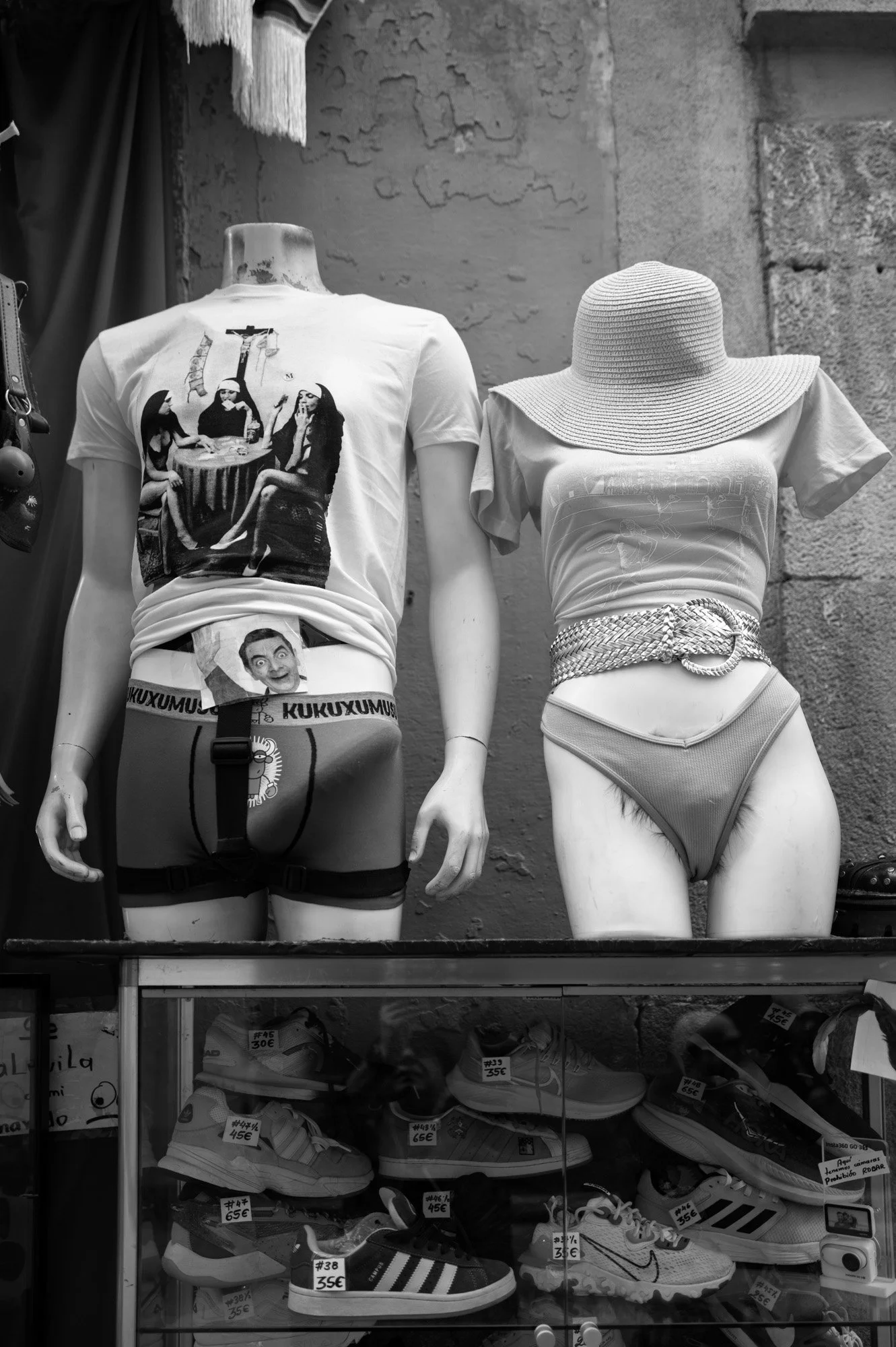 Headless mannequins dressed in irreverent clothing in a medieval stone doorway, Gothic Quarter Barcelona — Leica Q3