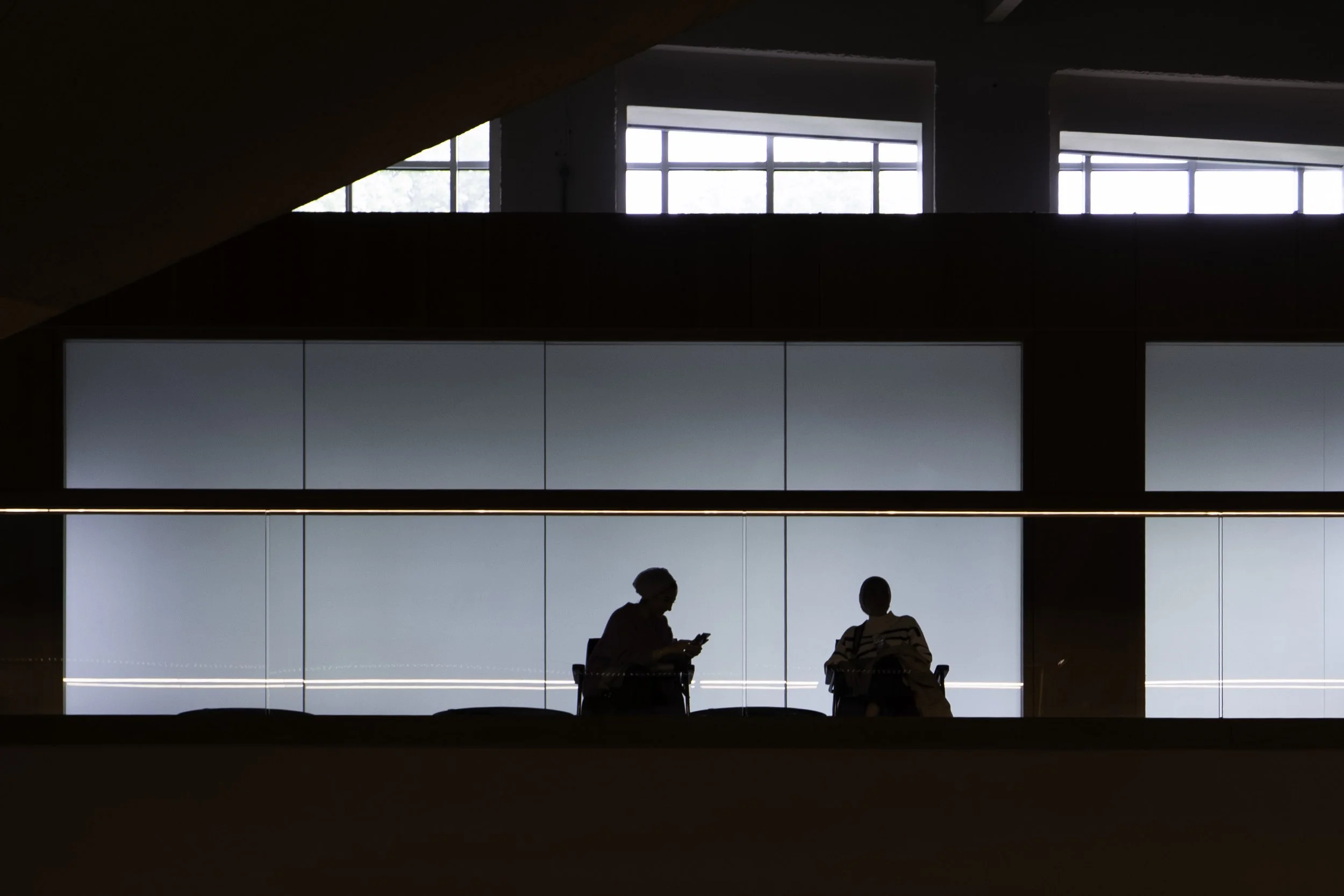 Two figures sitting and chatting on top of Battersea Power Station in London – street photography – bCLPhoto