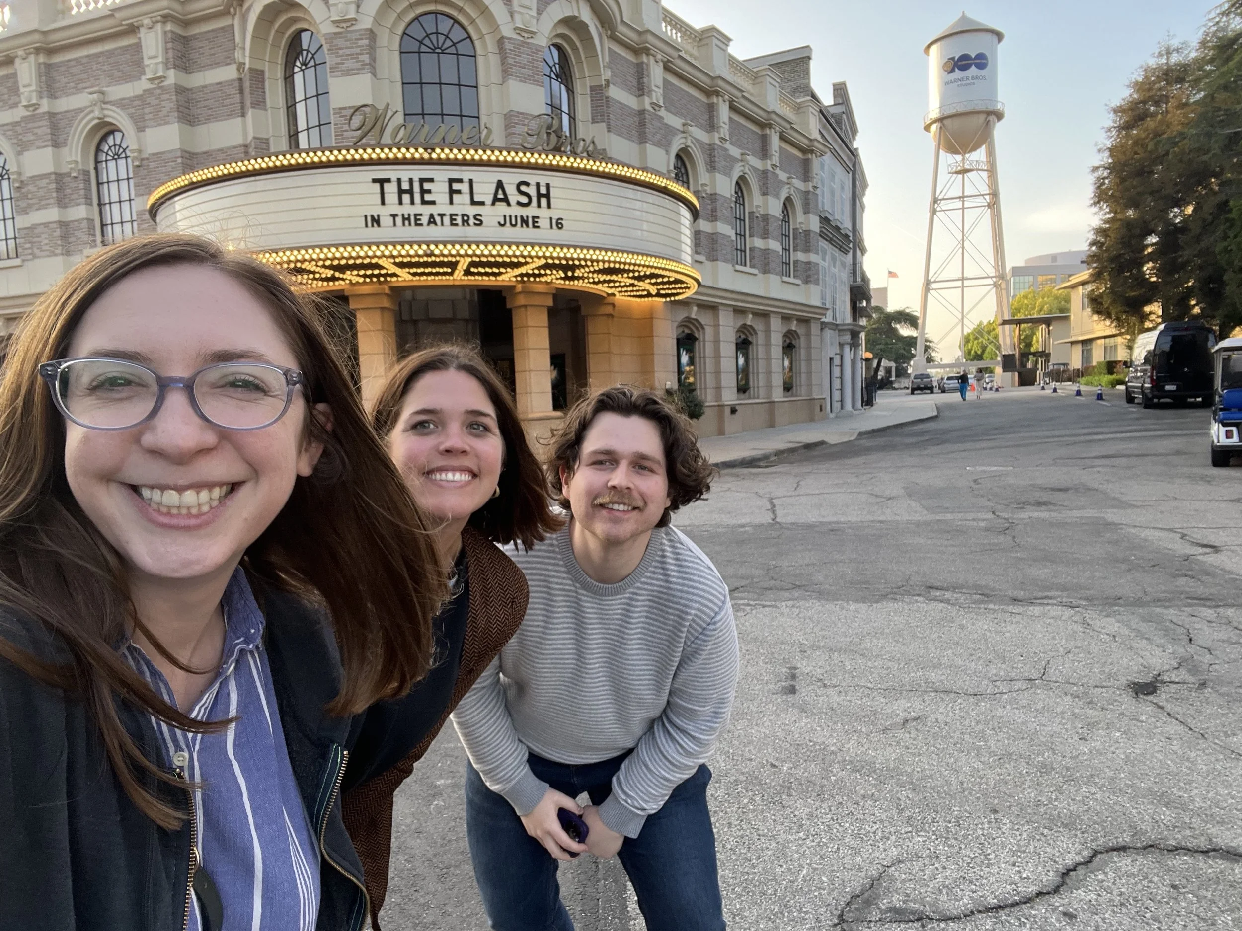 Esther and Team smile in front of The Flash marquee