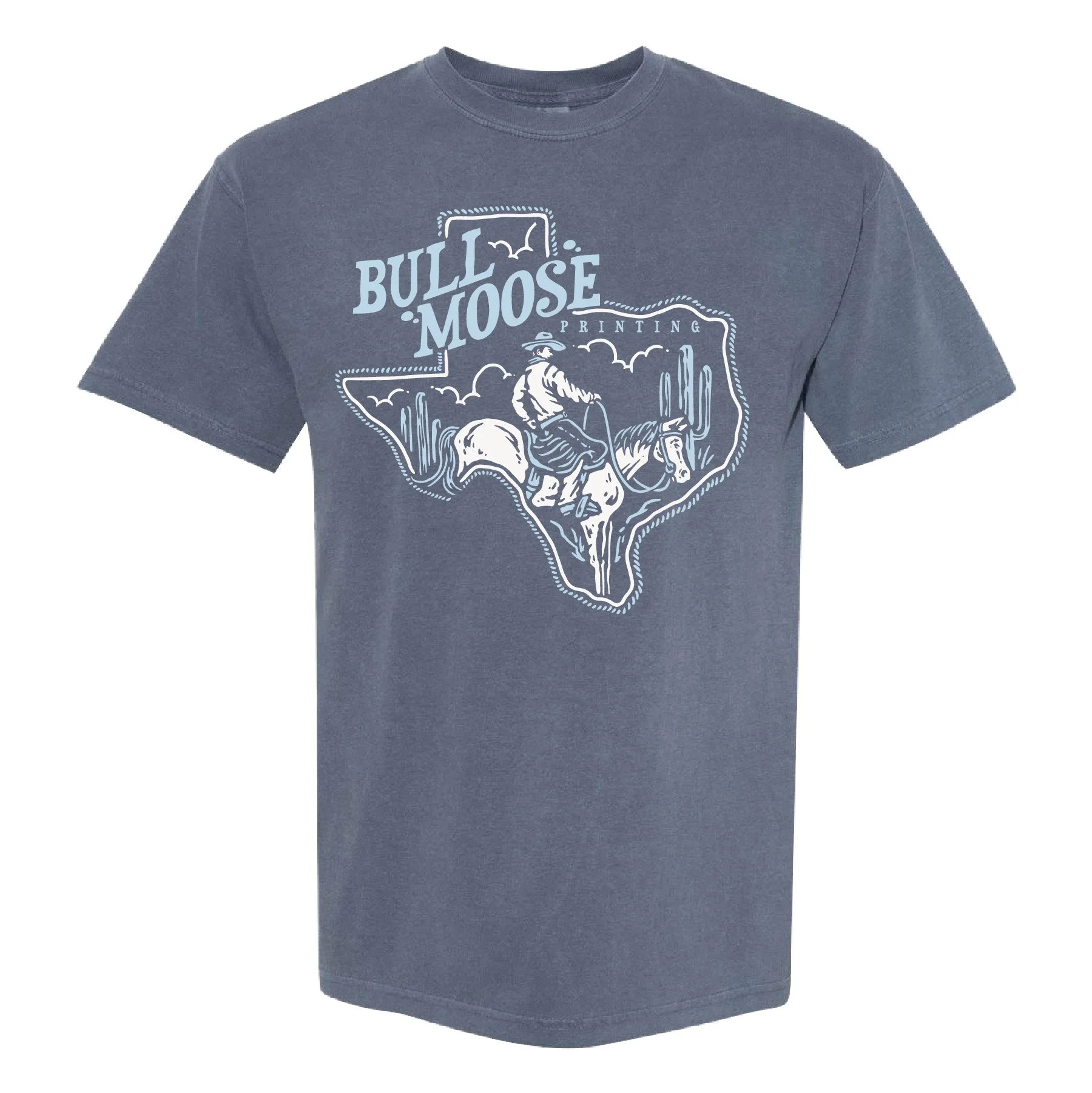 A blue T-shirt with a graphic design featuring a cowboy riding a horse inside the shape of Texas, with cacti and clouds, and the text 'Bull Moose Printing'.