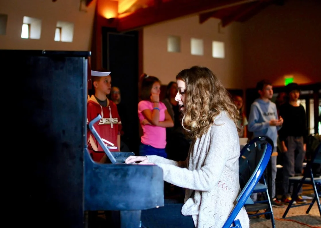 Pathway student playing piano on stage during the school Christmas production