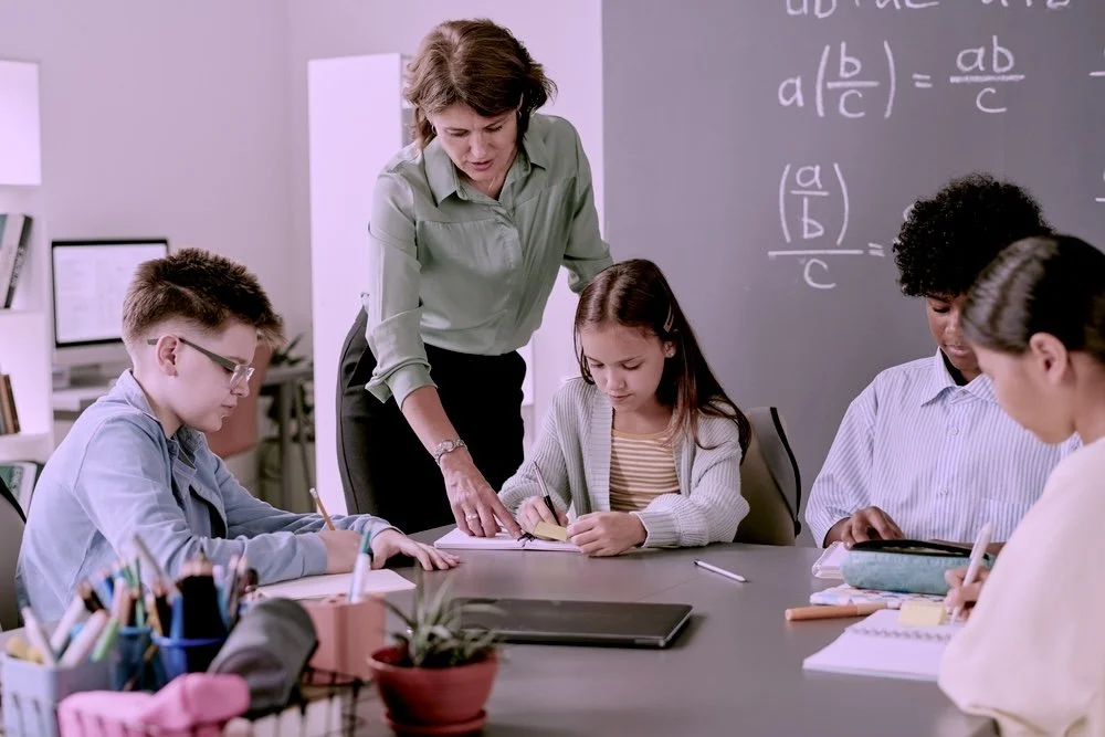 Teacher guiding a small group of students in a classroom