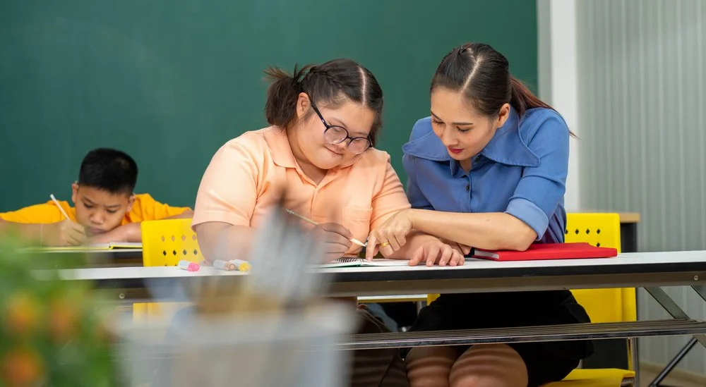 Female teacher instructing a student with special needs