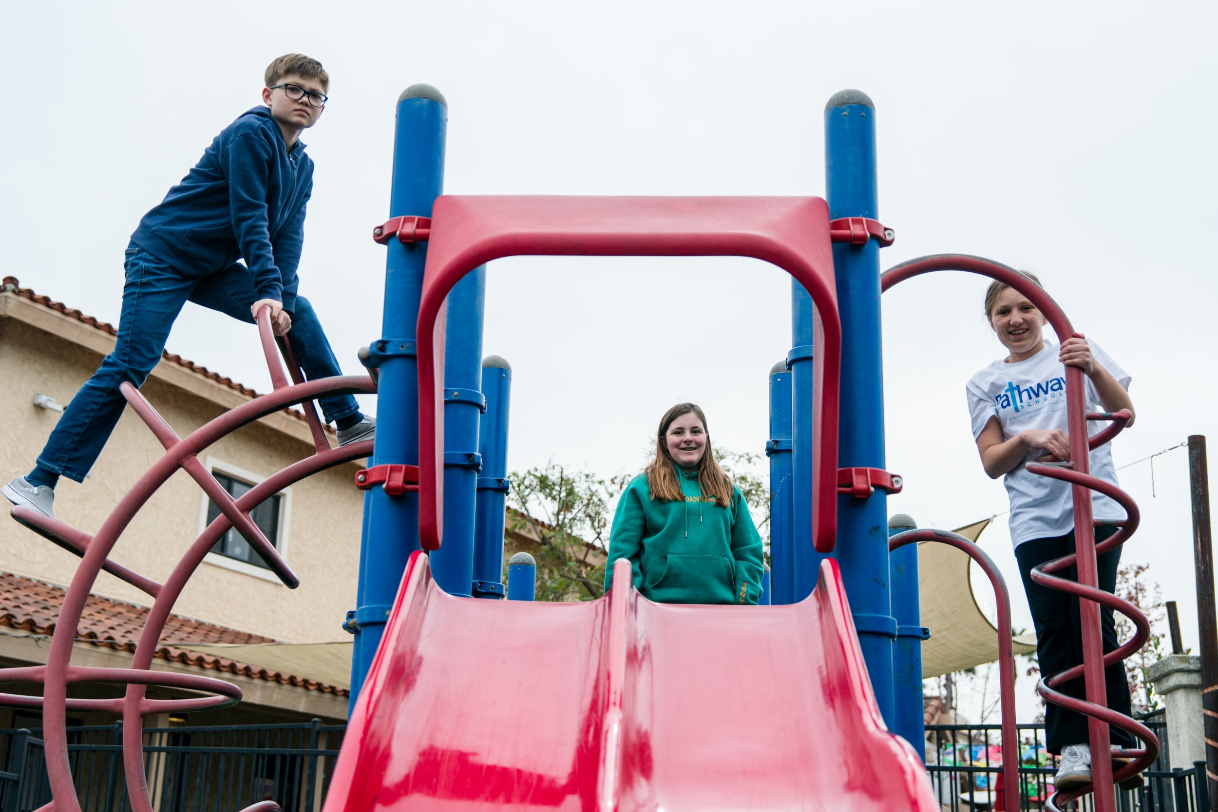 Three Pathway students playing together on the school playground