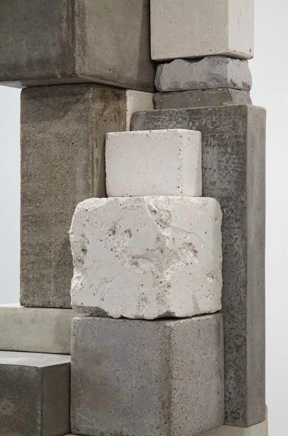 Stack of variously sized and textured concrete blocks.