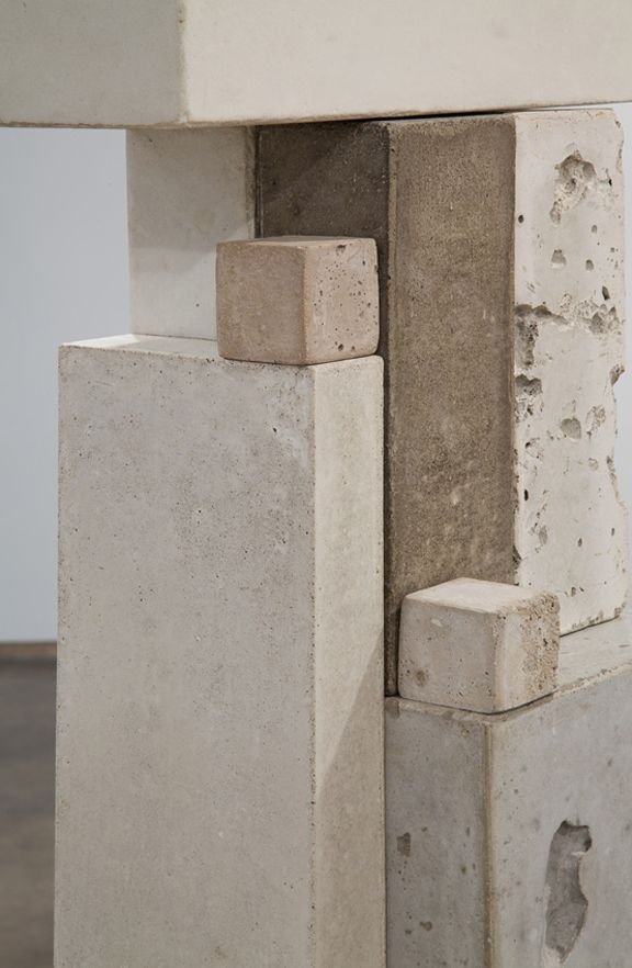 Close-up of stacked concrete blocks with varying textures and colors, creating an abstract geometric composition.