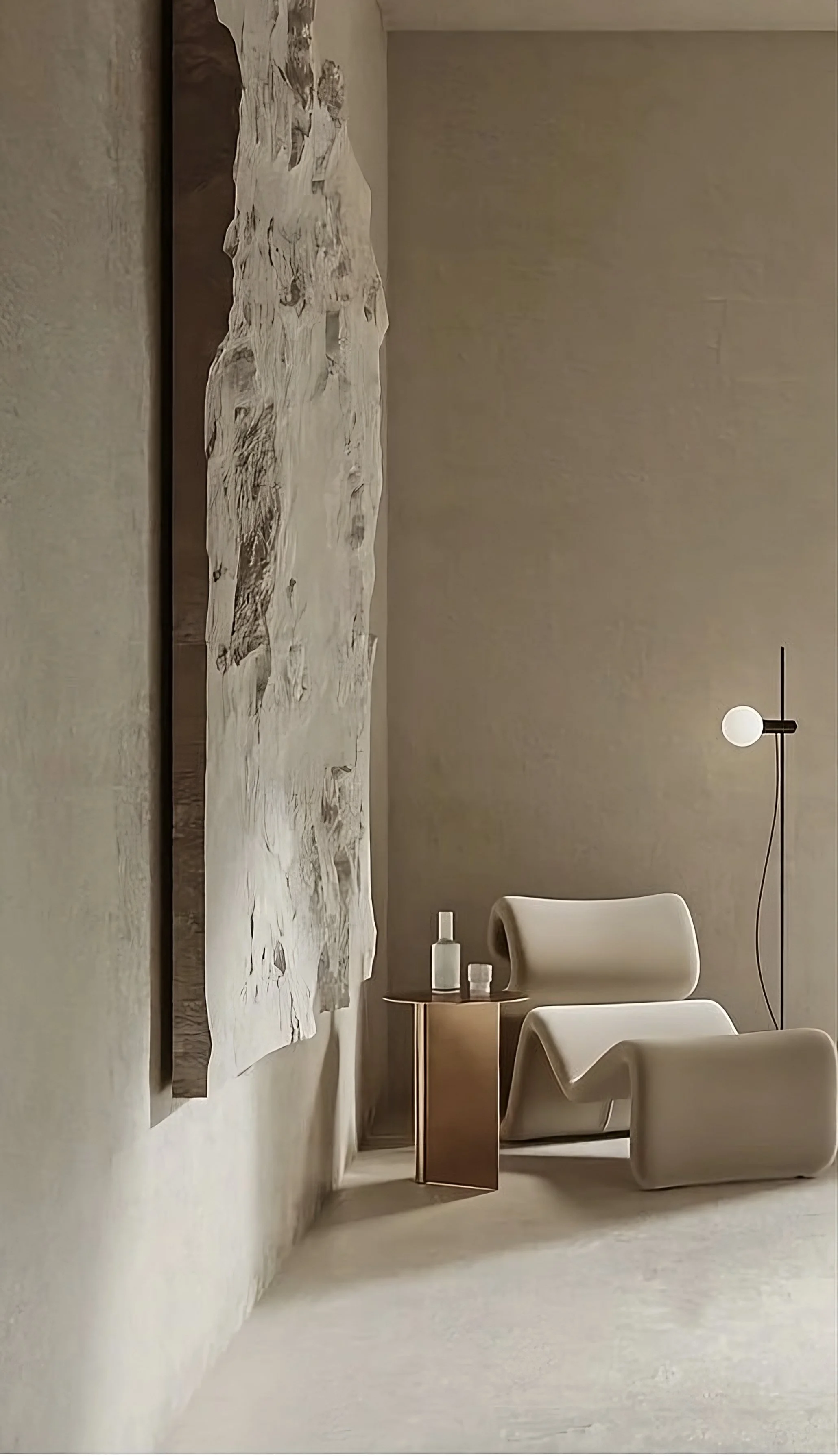 Minimalist interior with a sculptural white chair, abstract wall art, modern floor lamp, and small side table with bottles.