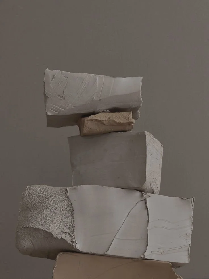 Stack of textured clay blocks against a gray background