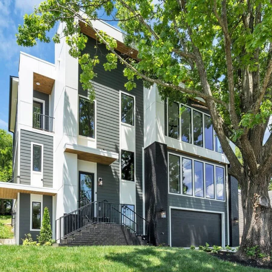 Modern multi-story home in white, grey, and black with multiple long rectangular windows.