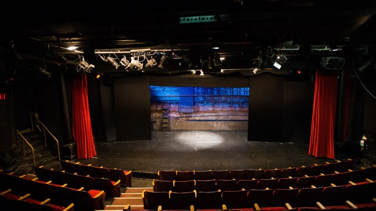 Dark theatre photos with dramatic velvet red drapes and an empty stage with spotlight.