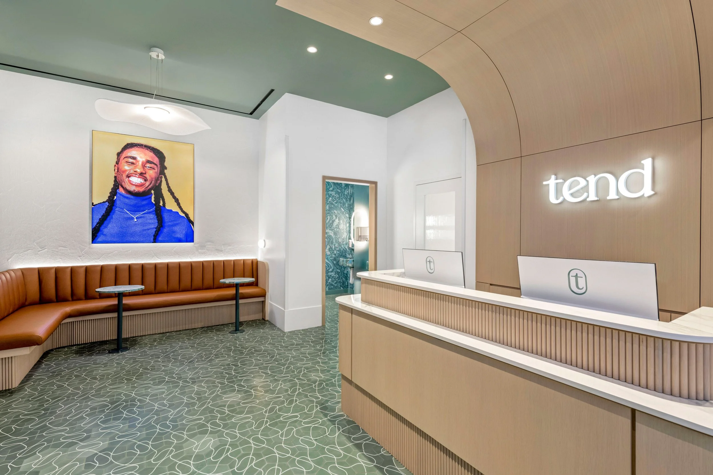 Modern interior of a Tend nail salon reception area with a curved wooden wall, illuminated