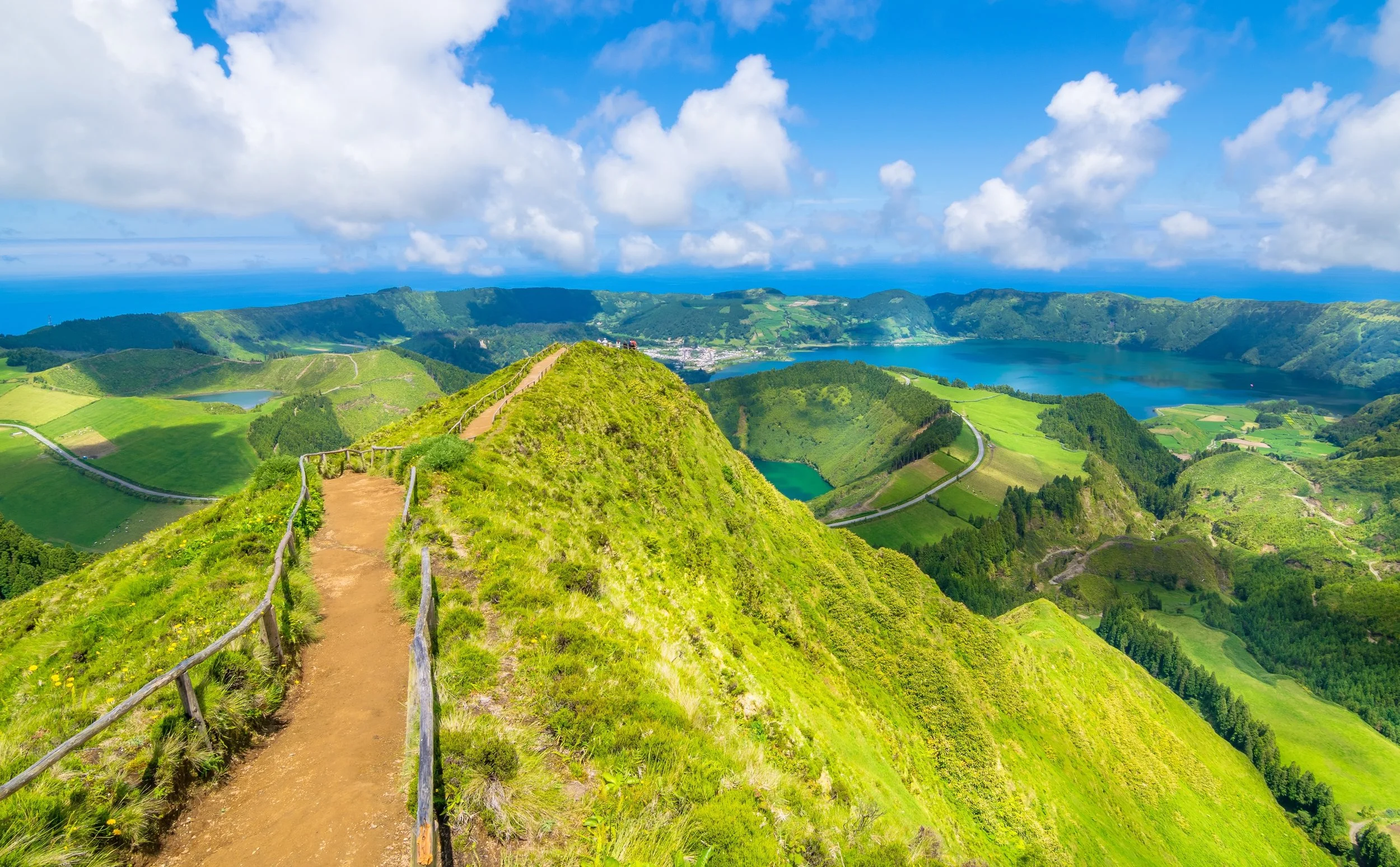 Hiking path above two crater lakes with clouds above