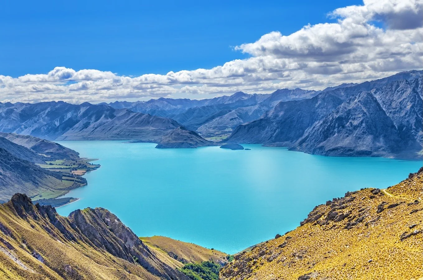 Turquoise Lake Hawea from above ringed by rugged grey mountains