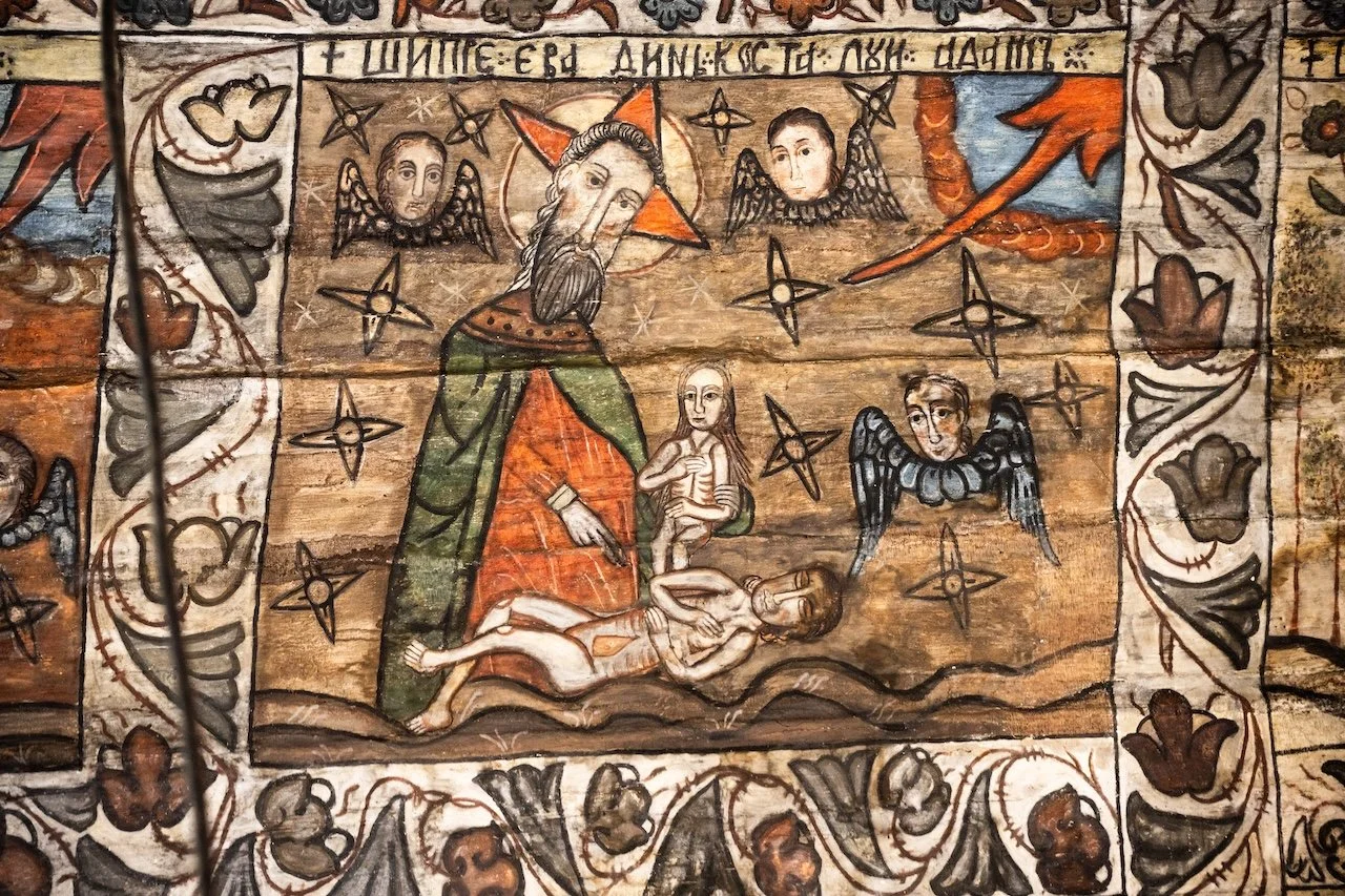 A traditional religious painting on wood depicting the Nativity scene with Jesus, Mary, and Joseph surrounded by angels, stars, and decorative borders.