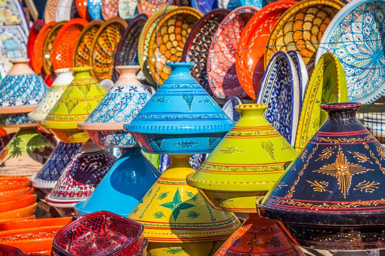 Colorful Mexican pottery and decorative plates on display at an outdoor market.