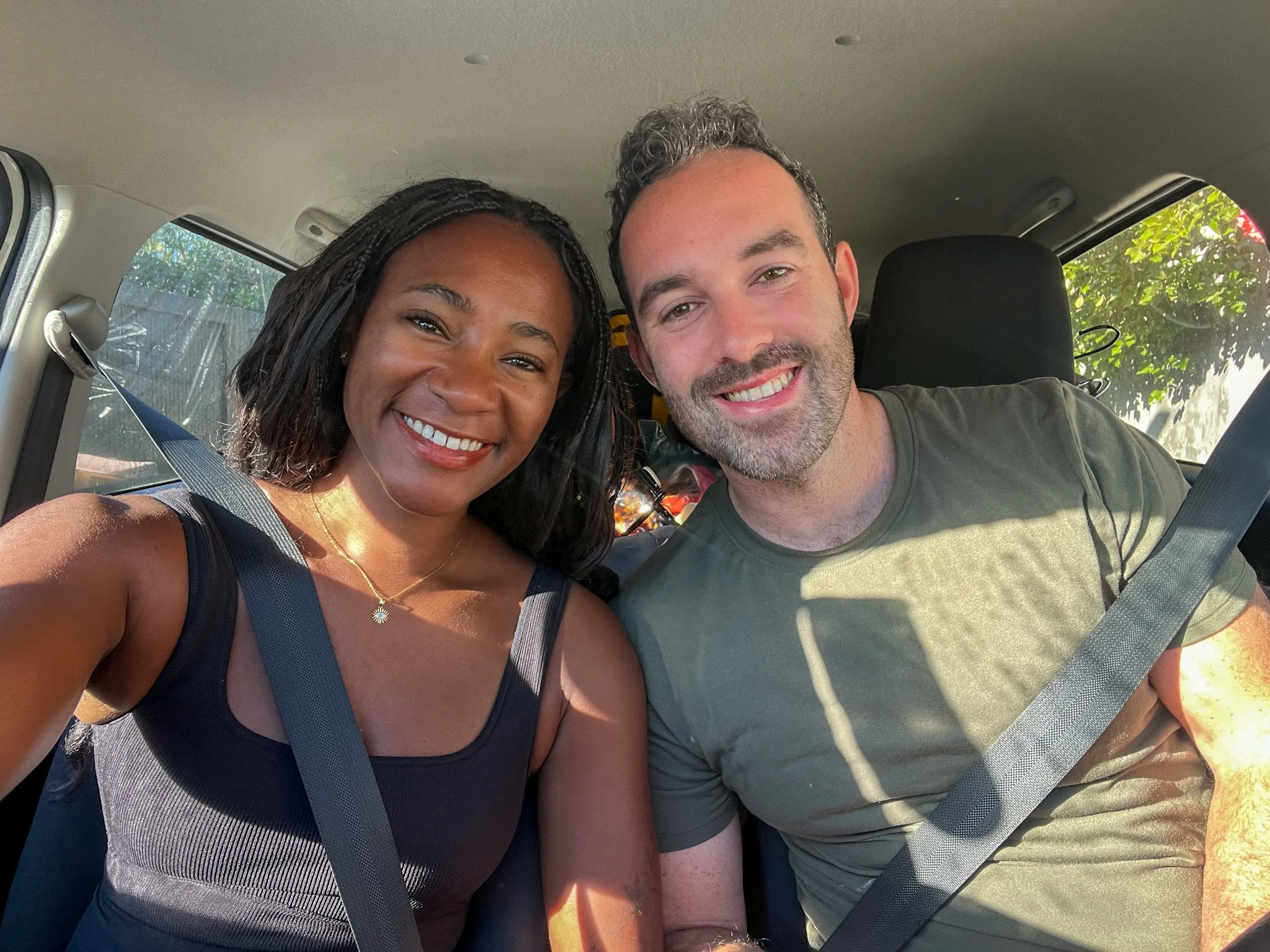 My husband and I in a rental car with our luggage in the back, still moving four years after I left